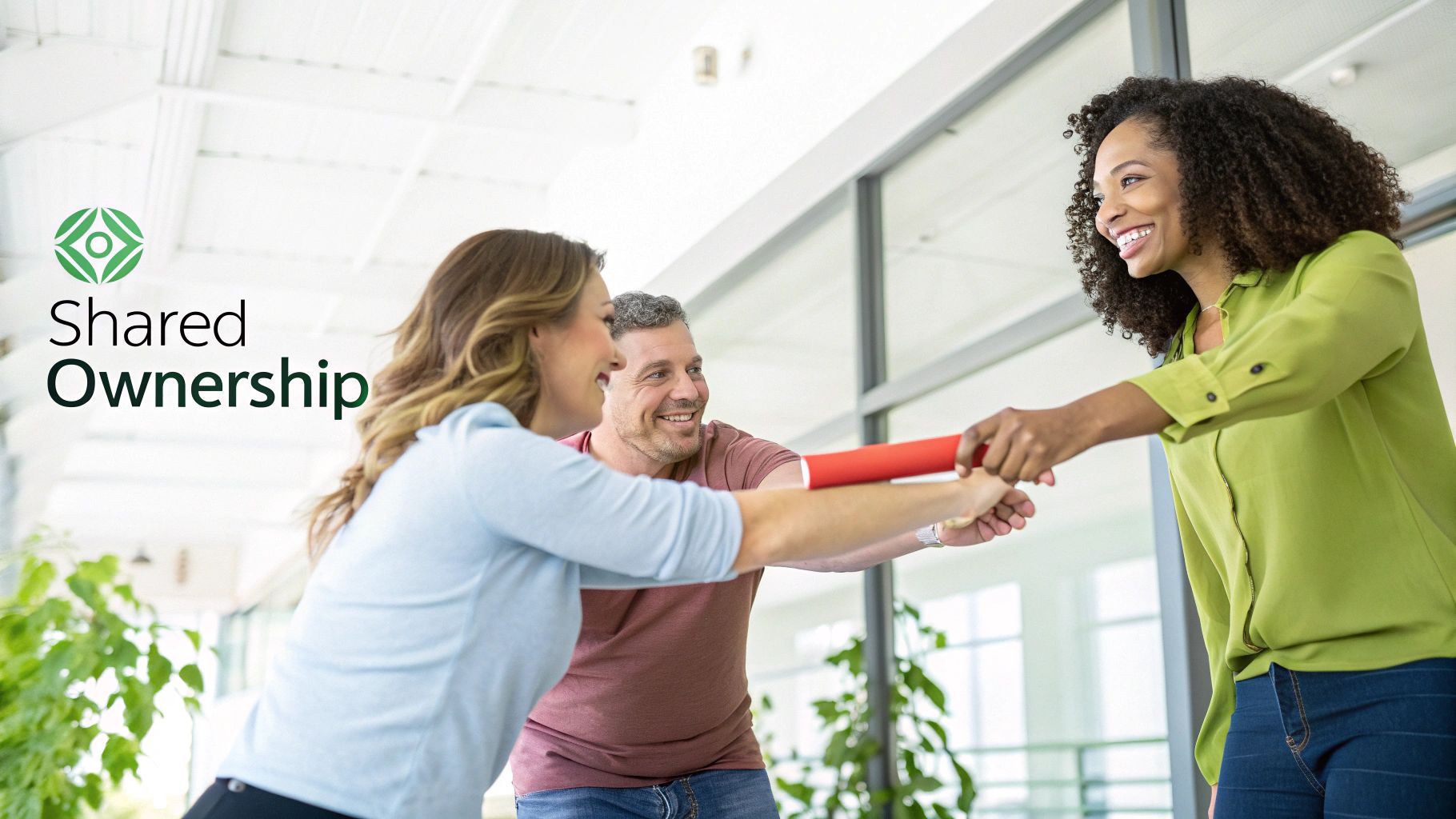 Three smiling diverse colleagues collaborate, passing a red baton, symbolizing shared ownership and teamwork.