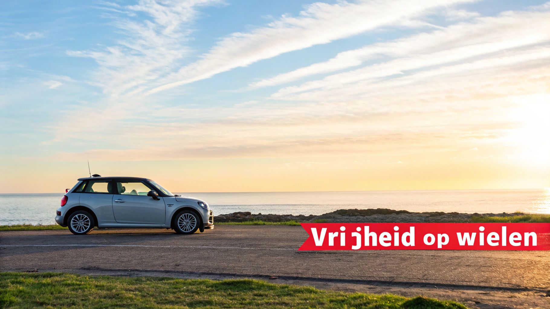 Een zilverkleurige Mini Cooper geparkeerd aan de kustlijn bij zonsondergang met de tekst 'Vrijheid op wielen'.