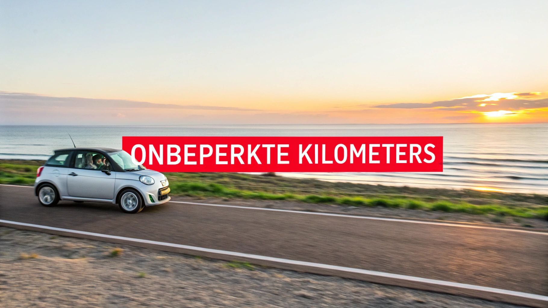 Zilveren auto rijdt langs de kustweg tijdens zonsondergang met de tekst "Onbeperkte Kilometers" in een rode balk.