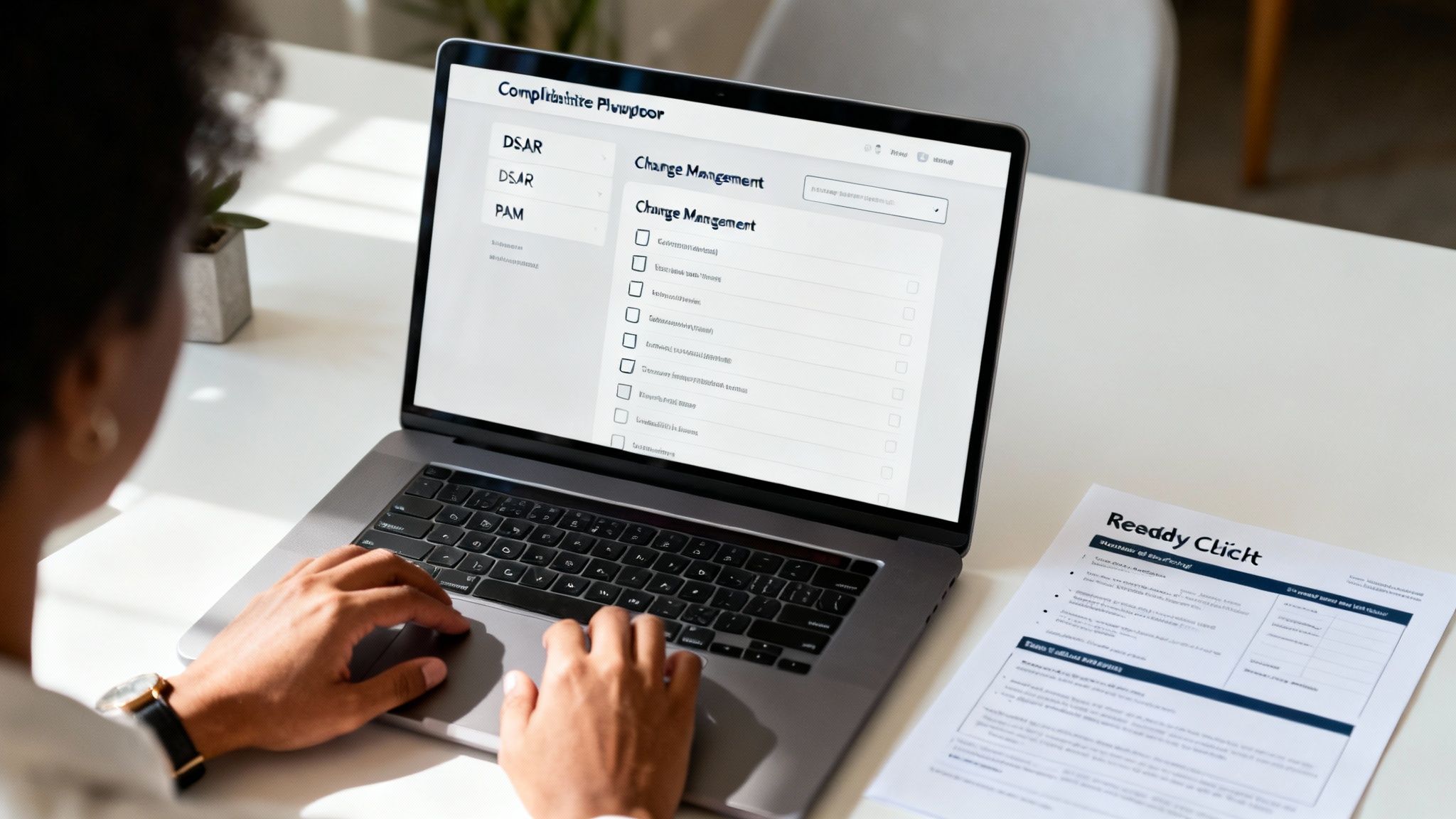 A person works on a laptop displaying compliance and risk management software.