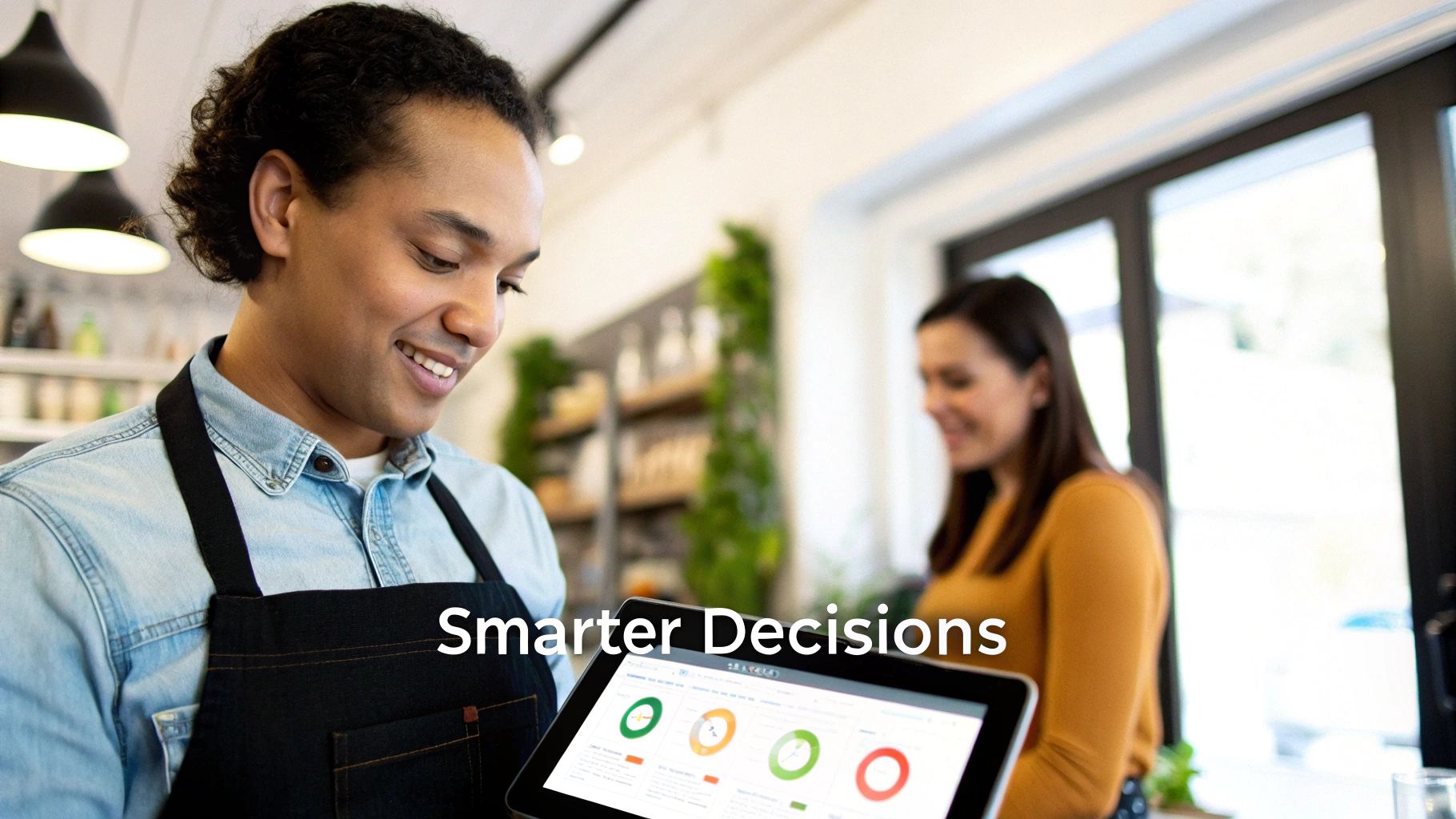 Happy male small business owner analyzing sales data on a tablet for smarter business decisions.