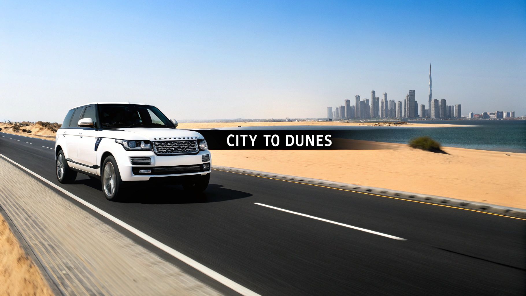 Your Ultimate Guide to a Range Rover Rental in Dubai 3 A white Range Rover SUV drives on a desert road with a city skyline and ocean in the background, under a clear blue sky.