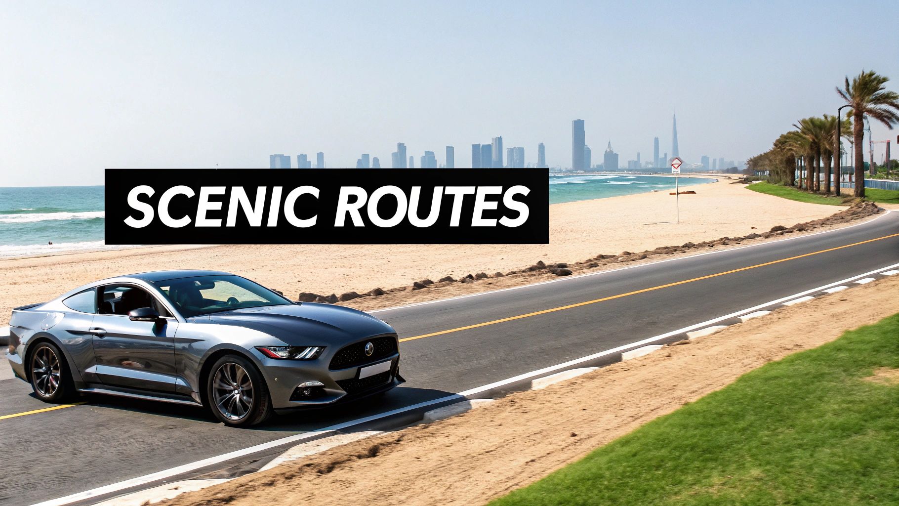 Your Guide to Mustang for Rent in Dubai 4 A silver Ford Mustang drives on a scenic coastal road alongside a beach, ocean, and Dubai skyline.
