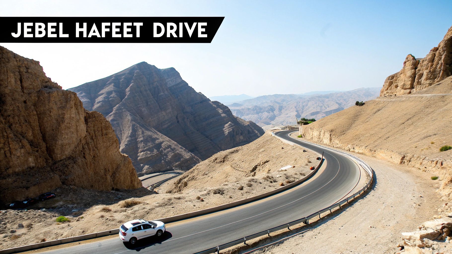 Scenic Jebel Hafeet Drive with a white SUV on a winding mountain road in the desert.