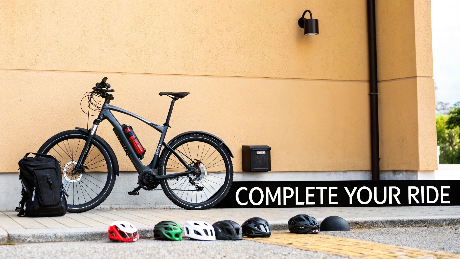 Rower elektryczny, czarny plecak i kilka kolorowych kasków są wyświetlane na żółtej ścianie z napisem „UKOŃCZ JAZDĘ”.