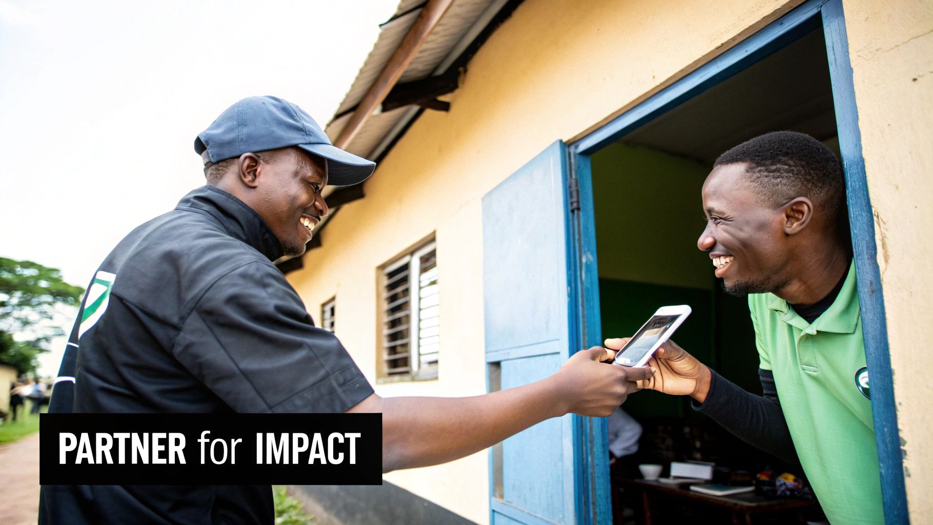Two smiling men exchanging a white smartphone in a doorway, suggesting a tech interaction.