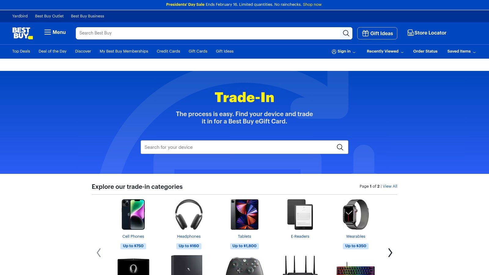 A Best Buy employee assessing a laptop for a trade-in at a store counter.