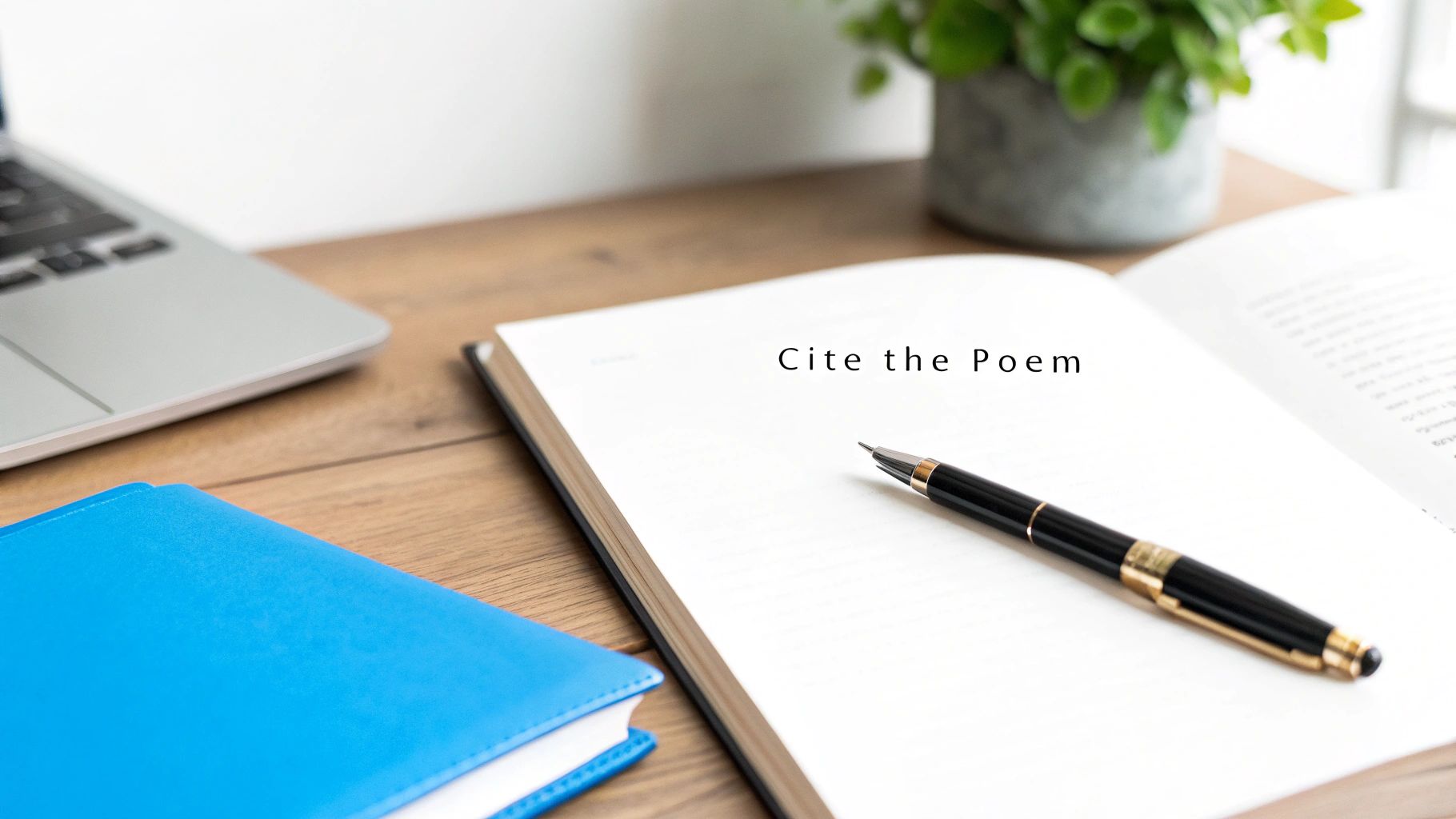 A close-up of a desk with an open book displaying 'Cite the Poem,' a pen, and a laptop.