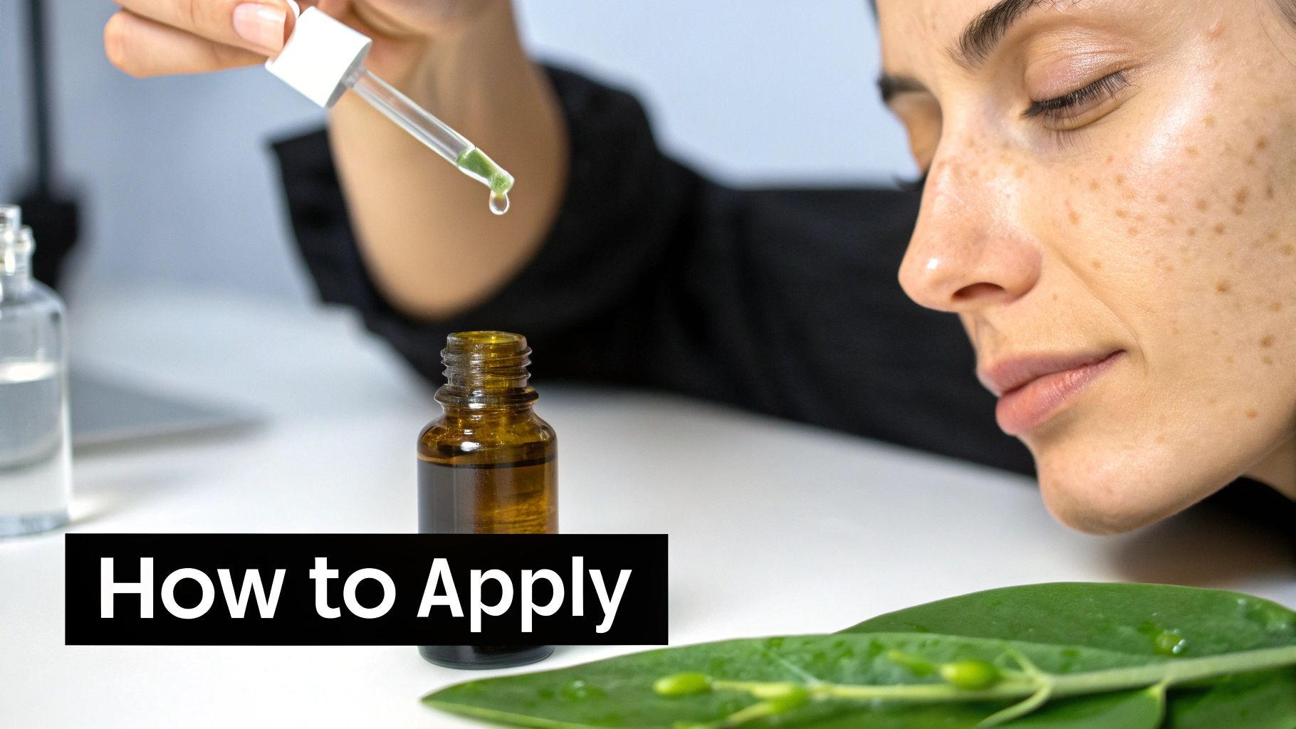 A woman with freckles is about to apply green serum from a dropper, next to a bottle and a green leaf.
