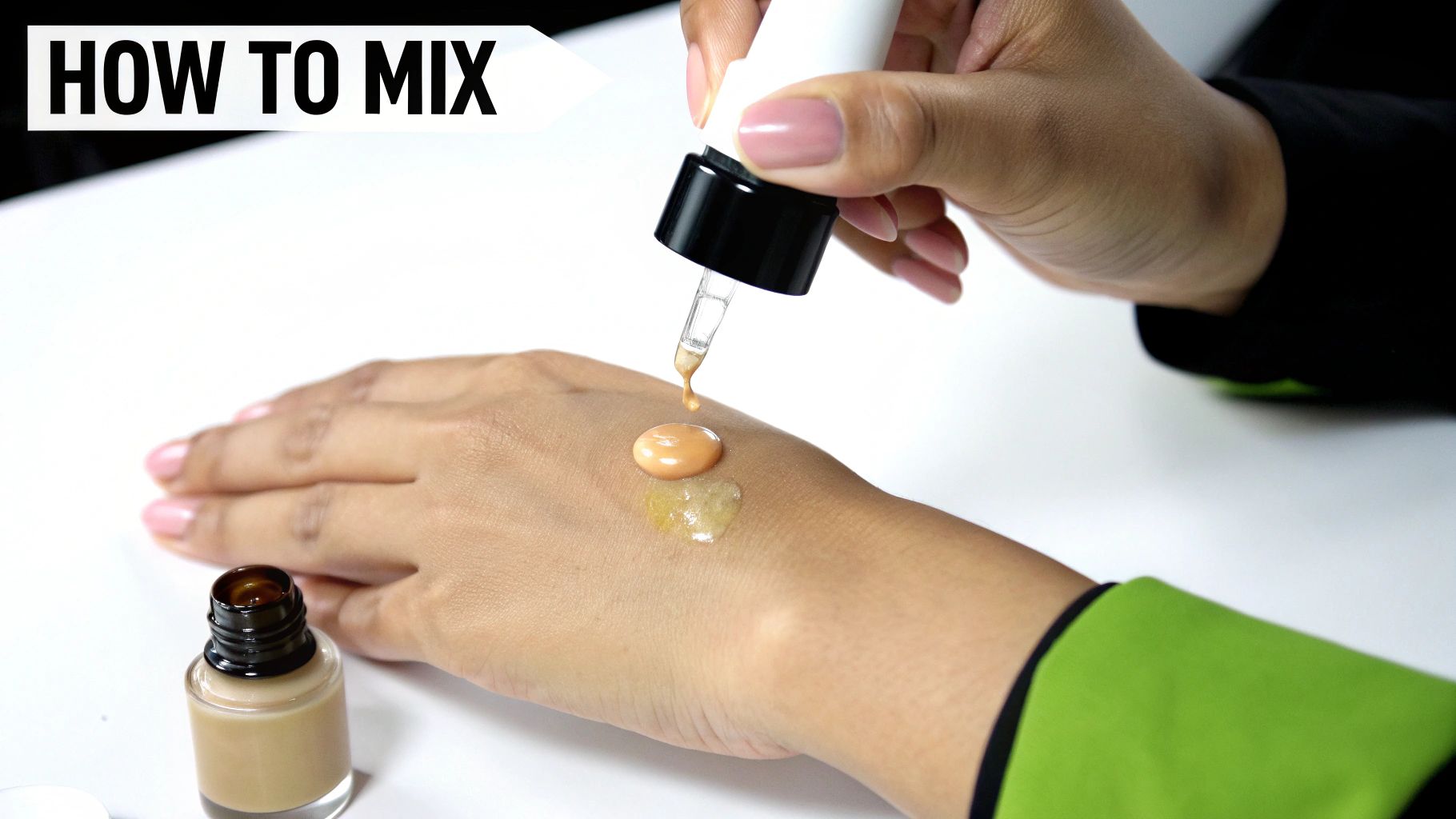 A person's hand demonstrating how to mix foundation or bronzing drops with a clear serum.