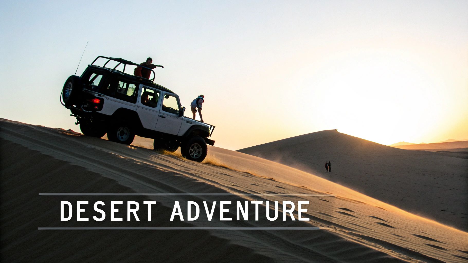 White SUV with people driving up a large sand dune at sunset in the desert.