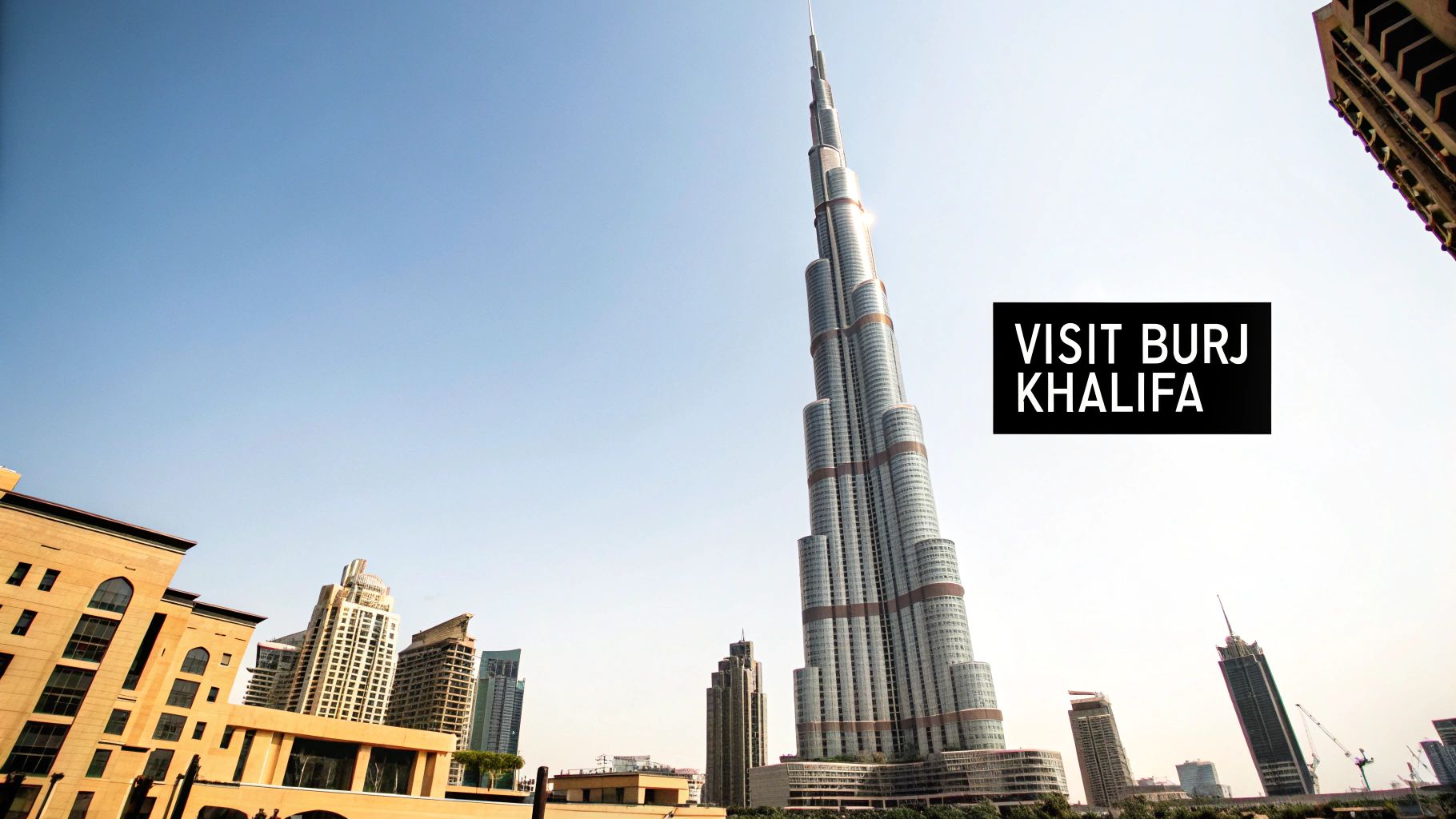 The towering Burj Khalifa, a famous skyscraper in Dubai, stands against a clear blue sky.