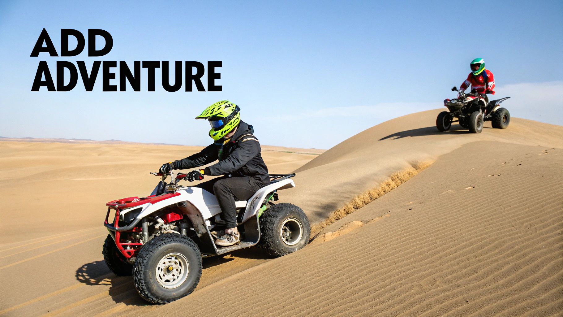 Two people on quad bikes riding up and down sand dunes in a vast desert landscape under a clear sky.
