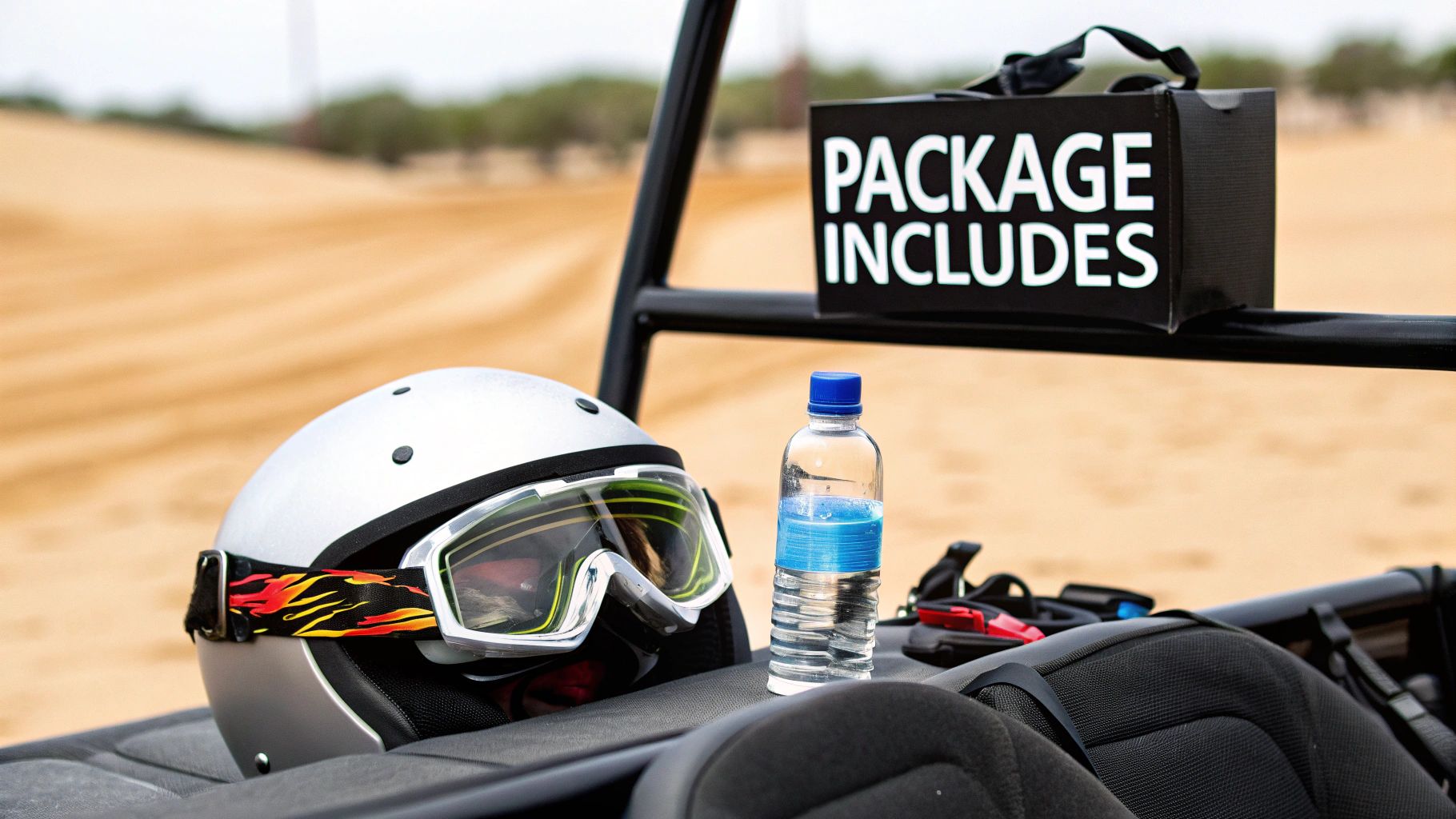 A silver helmet with flame goggles, a water bottle, and a 'Package Includes' box on a dune buggy seat in a desert.