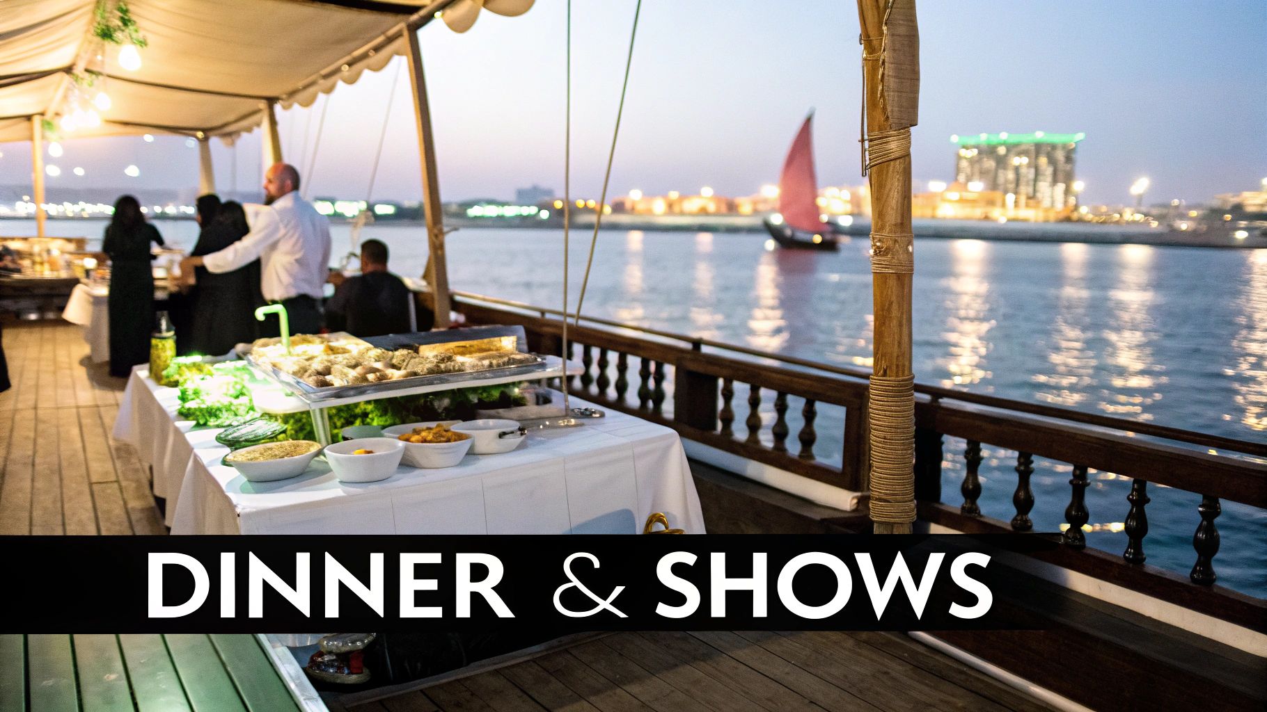 Guests enjoying a buffet dinner on a traditional dhow cruise at sunset, with city lights in the distance.