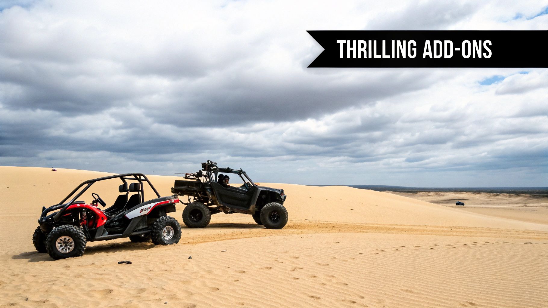 Two off-road vehicles, one red and one dark, on sandy desert dunes under a cloudy sky.