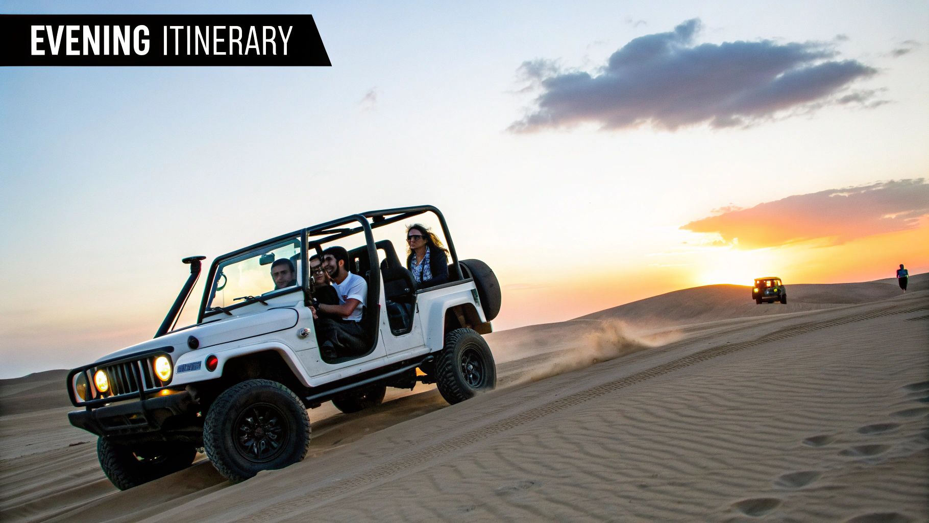 A white jeep with people driving through sandy desert dunes at sunset during an evening safari.
