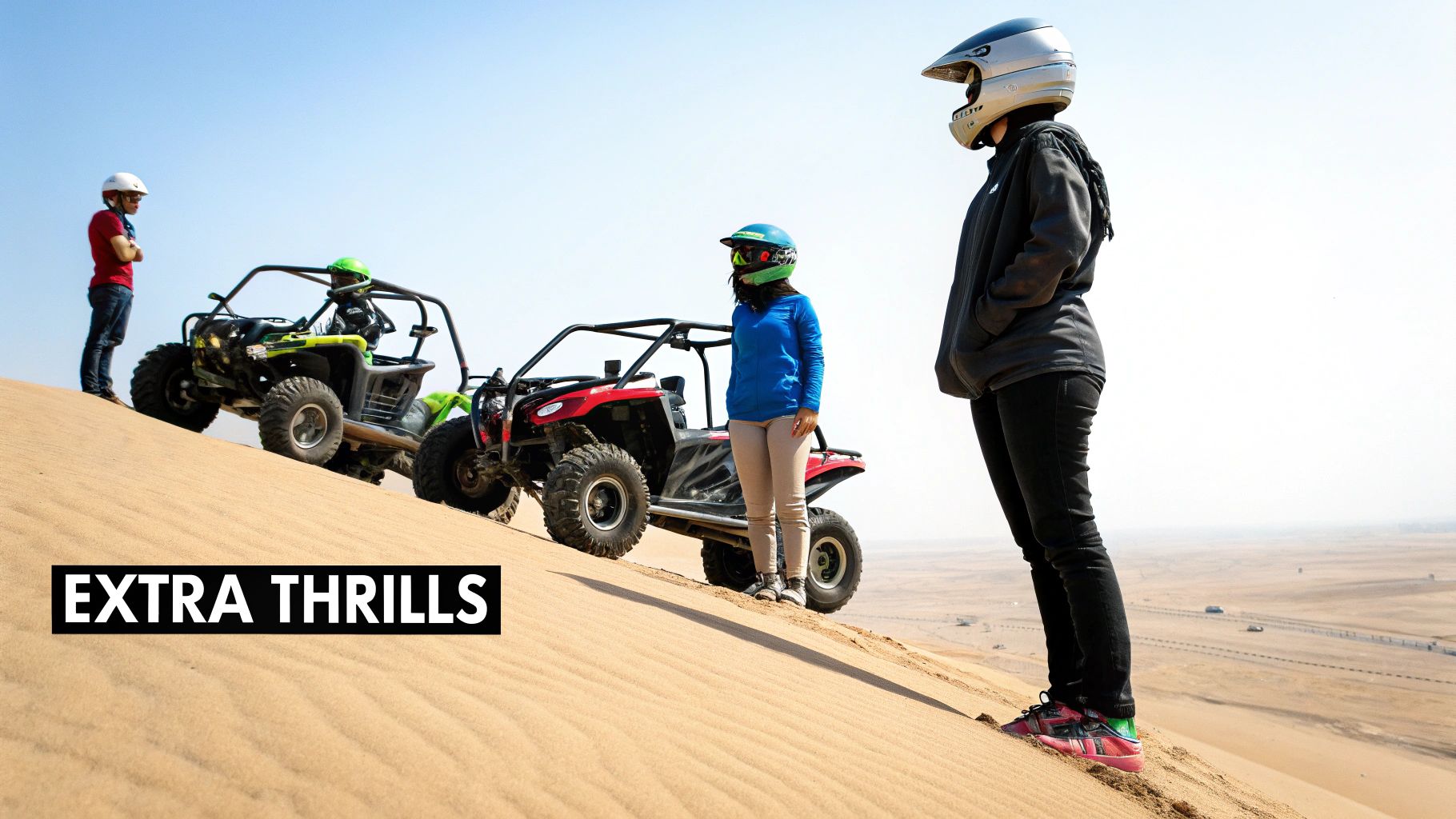 Adventure seekers in helmets with dune buggies on a vast desert landscape.