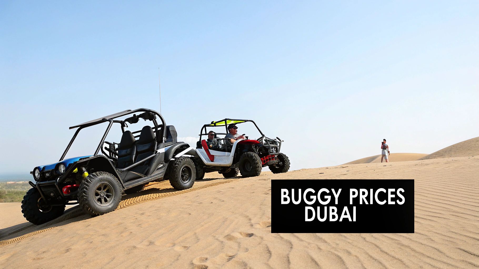 Two dune buggies on sandy desert dunes under a clear blue sky, with a person standing.