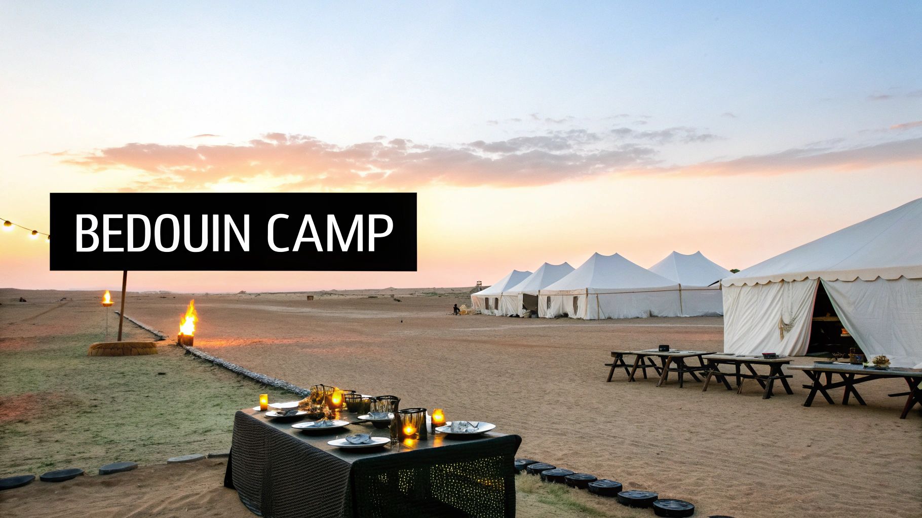 A beautiful desert Bedouin camp at sunset, featuring white tents, outdoor dining, and illuminated by firelight.