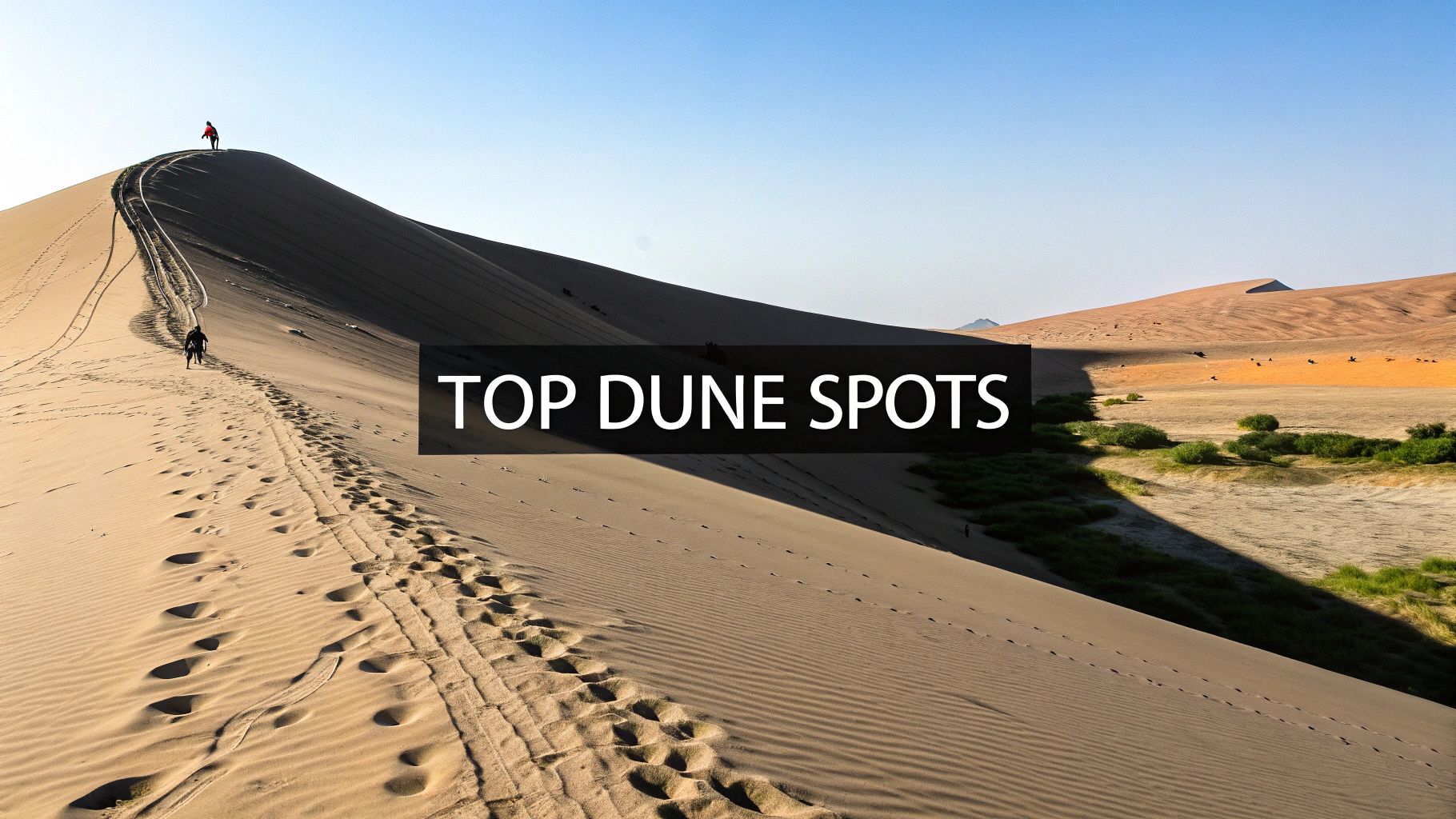 Dramatic sand dune with footprints and hikers ascending steep ridge in Dubai desert landscape
