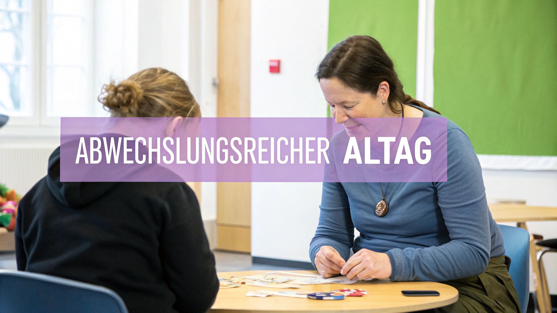Zwei Personen sitzen an einem Tisch, eine Frau lächelt und konzentriert sich auf Aktivitäten. Text: Abwechslungsreicher Alltag.