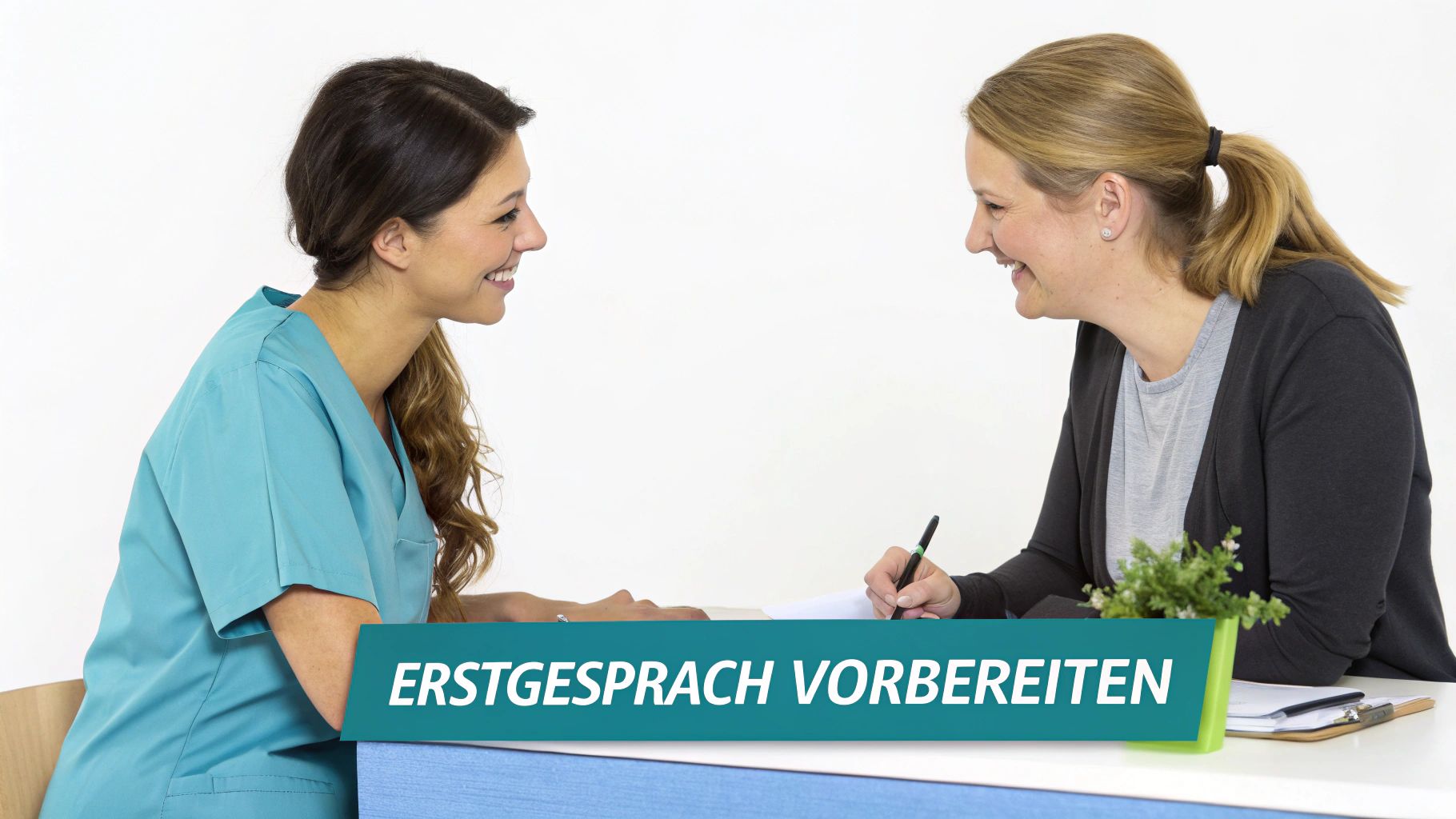 Zwei lächelnde Frauen bereiten ein Erstgespräch an einem Schreibtisch vor, eine schreibt Notizen.