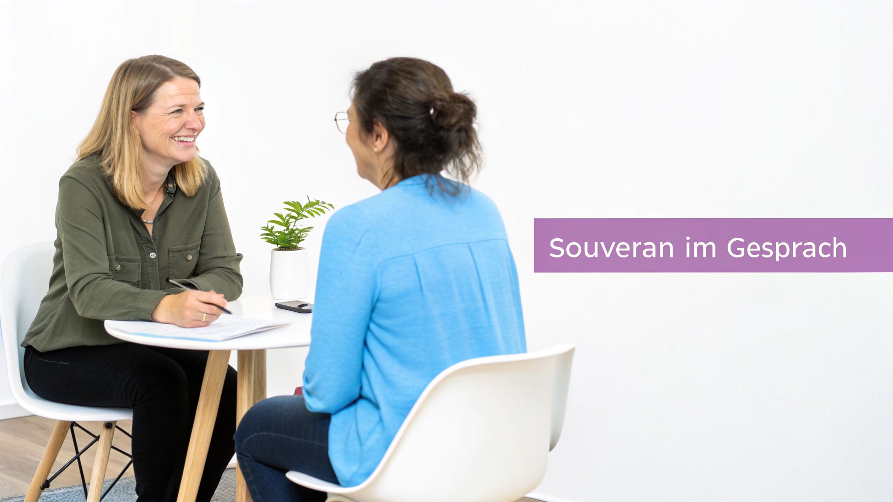 Zwei Frauen unterhalten sich am Tisch. Eine lächelt, die andere hört zu. Text: Souverän im Gespräch.