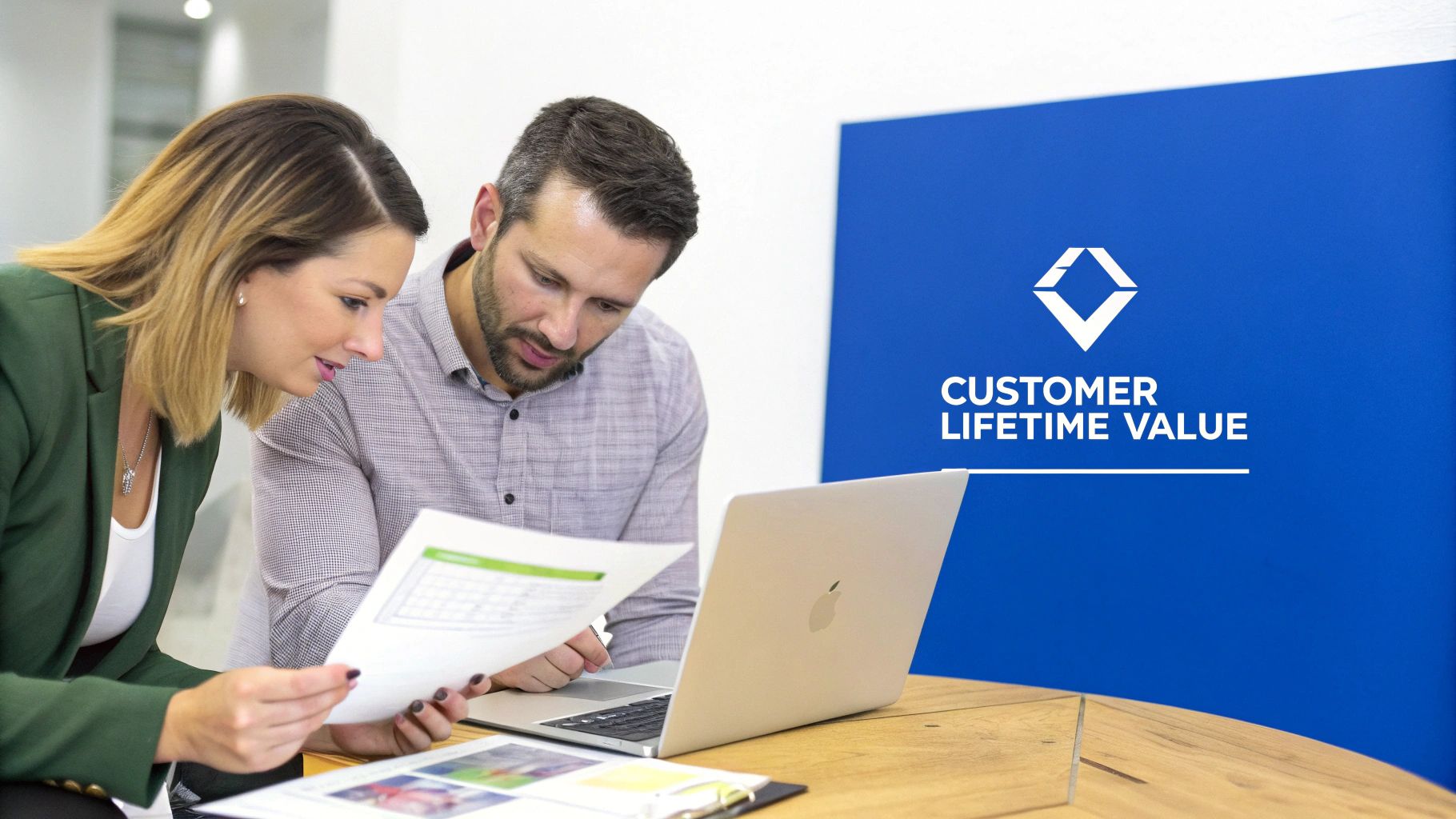 Two business professionals collaborating on documents and a laptop, with 'Customer Lifetime Value' sign in background.