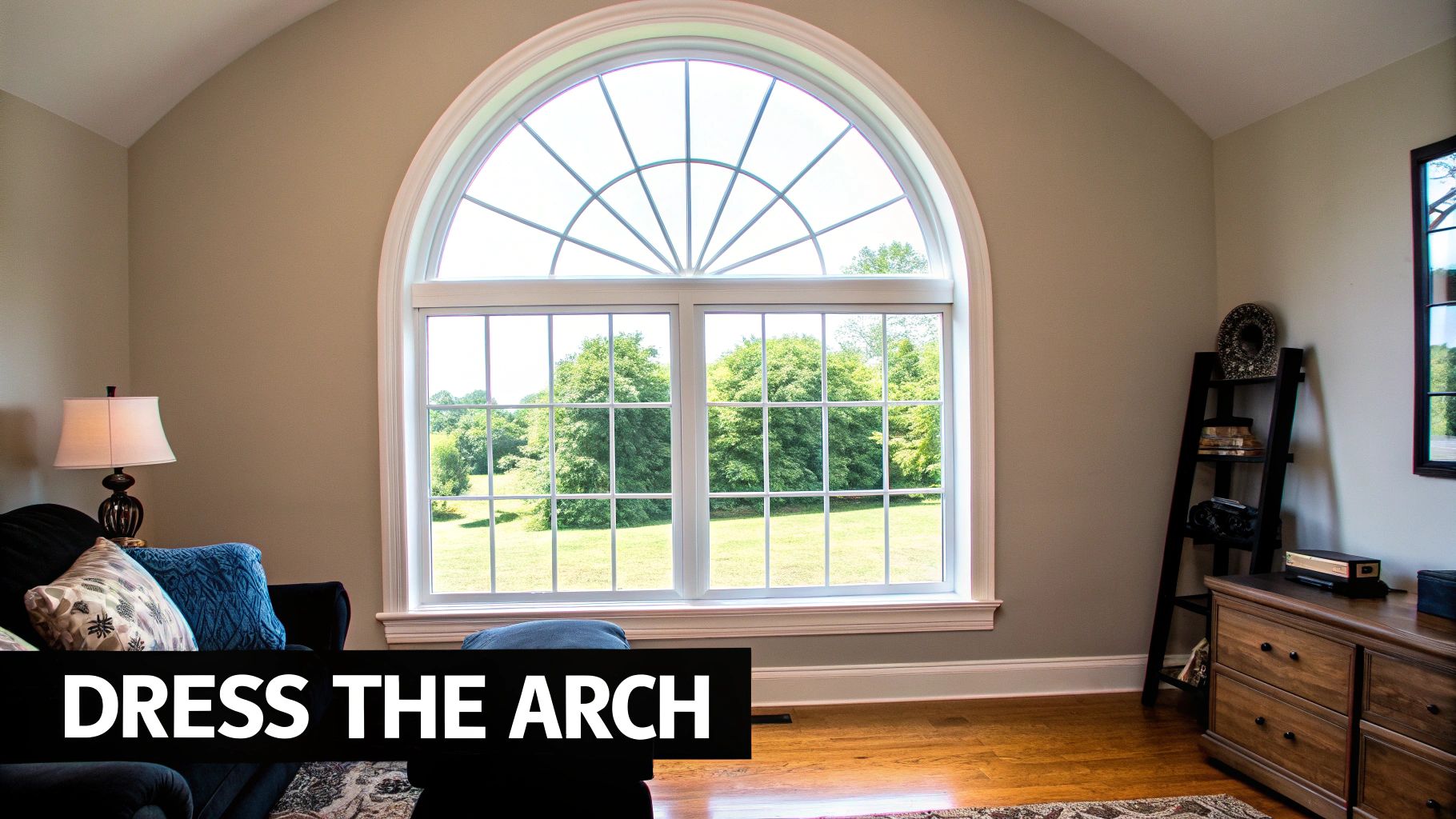 A large, light-filled living room featuring a prominent half-moon arched window with a scenic outdoor view.