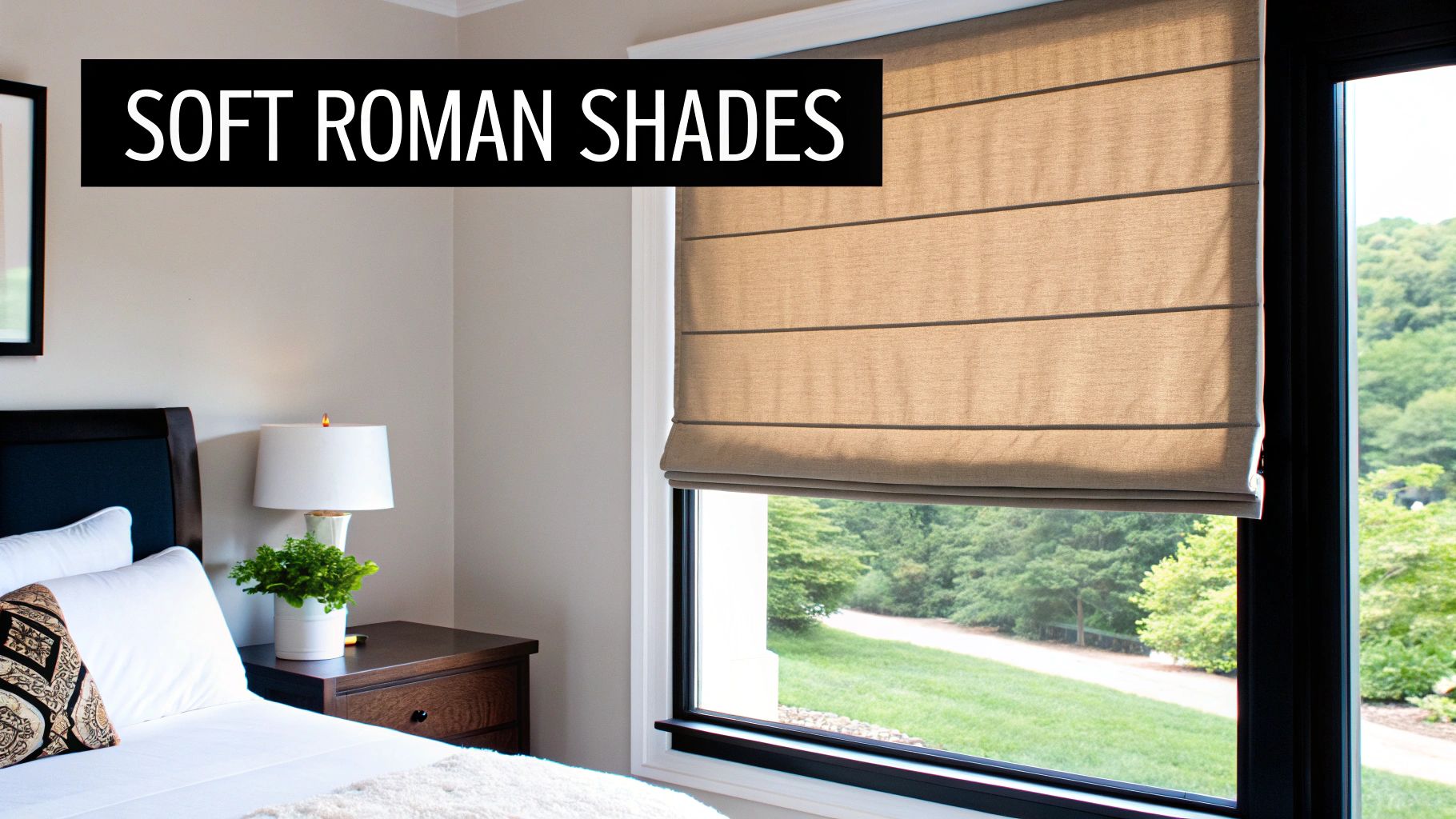 Soft beige roman shades partially lowered on large bedroom window overlooking green garden landscape