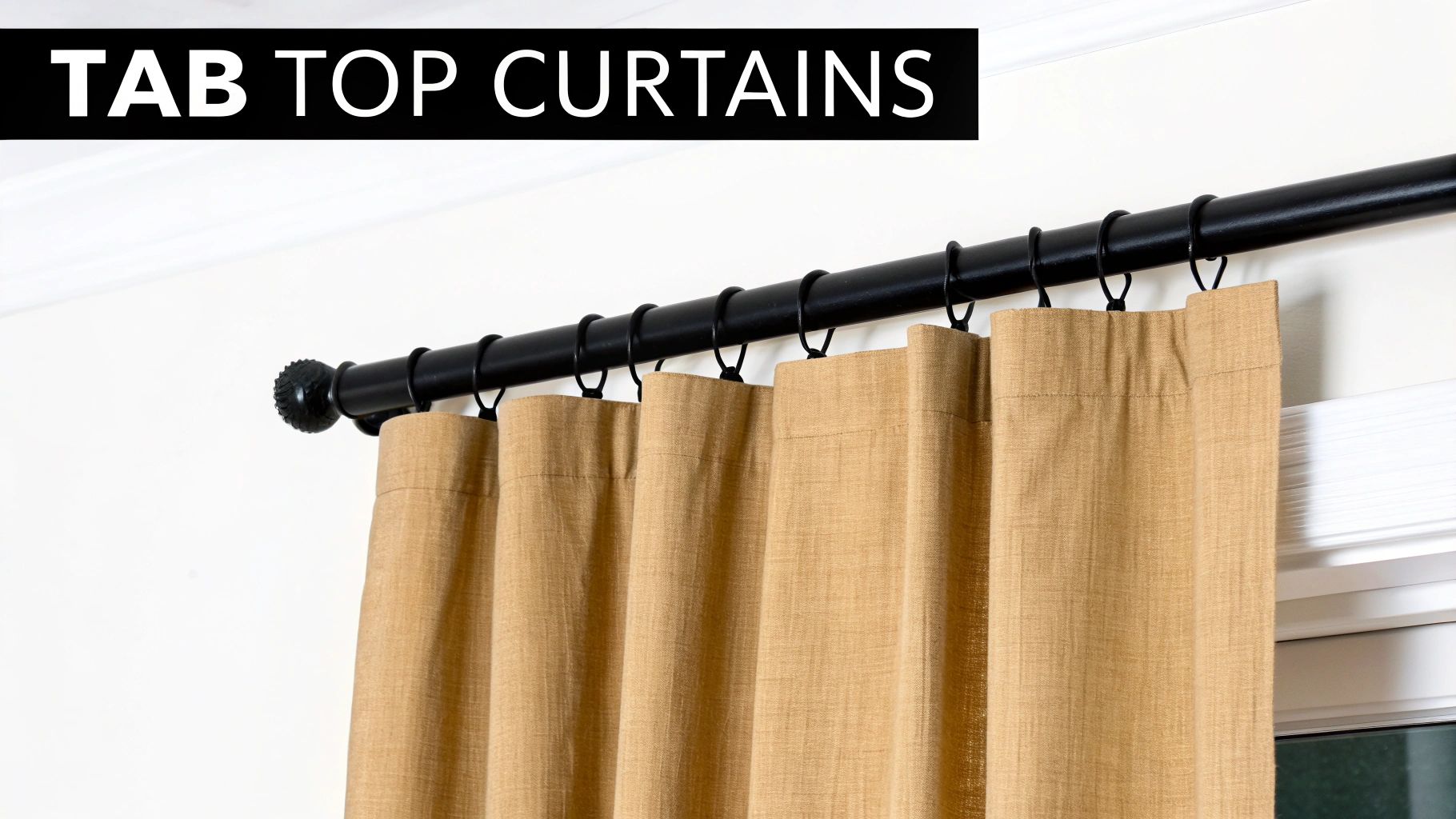 Close-up of light brown tab top curtains hanging on a black rod with rings.