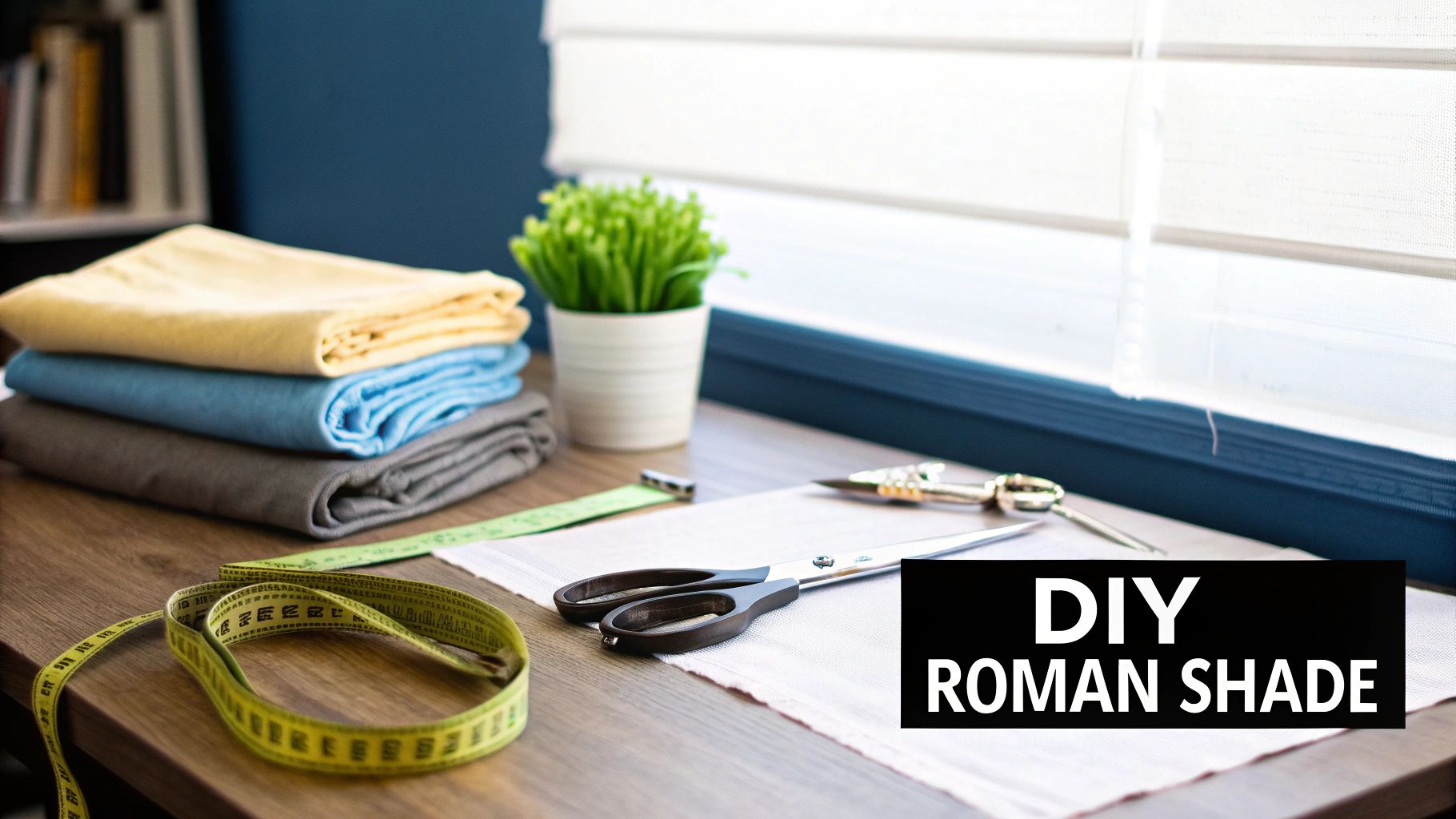 Crafting supplies on a desk, including fabric, scissors, and measuring tape, for a DIY roman shade project.
