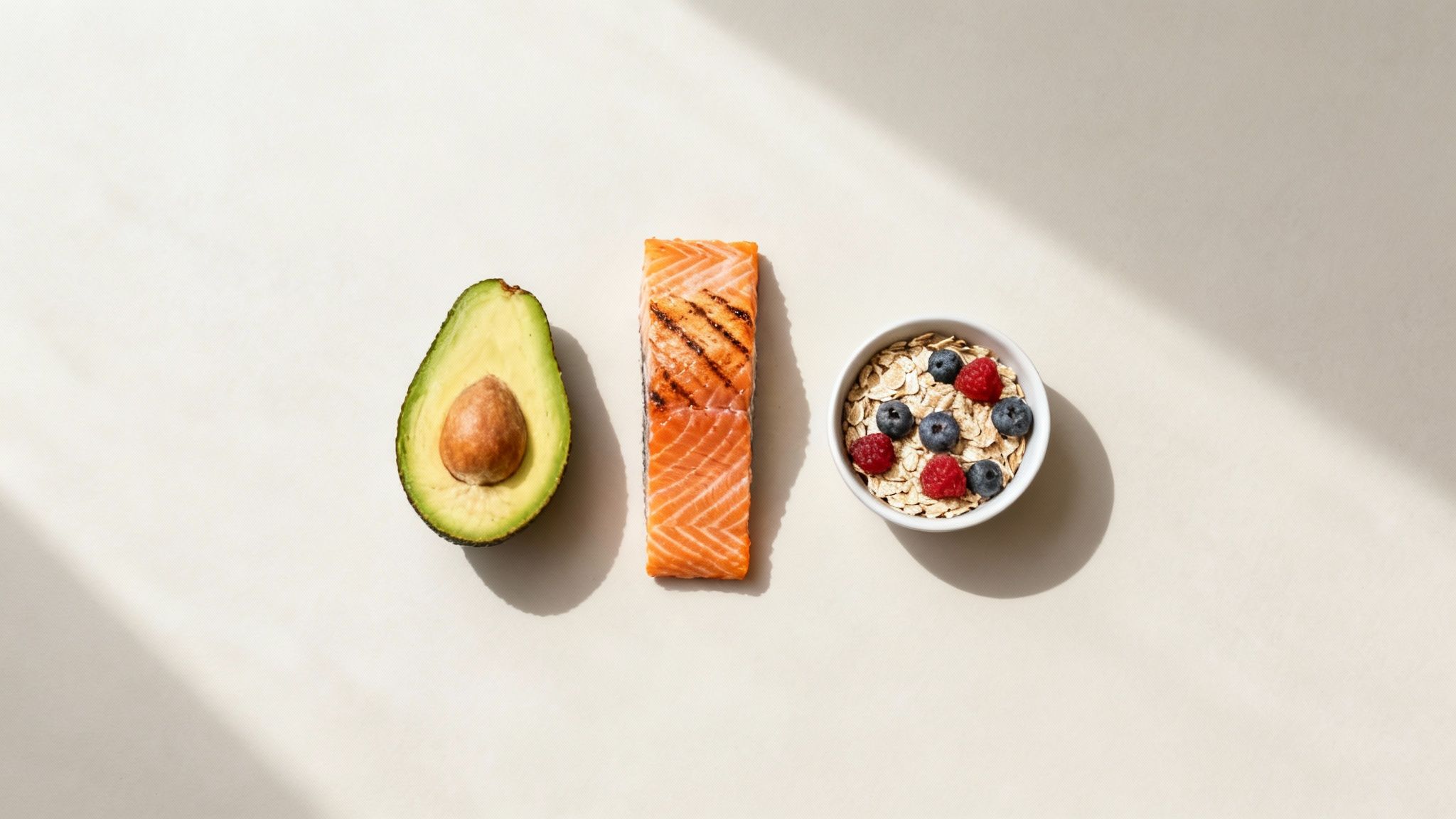 Eine Auswahl an protein-, fett- und ballaststoffreichen Lebensmitteln wie Lachs, Avocado, Nüsse und Gemüse.