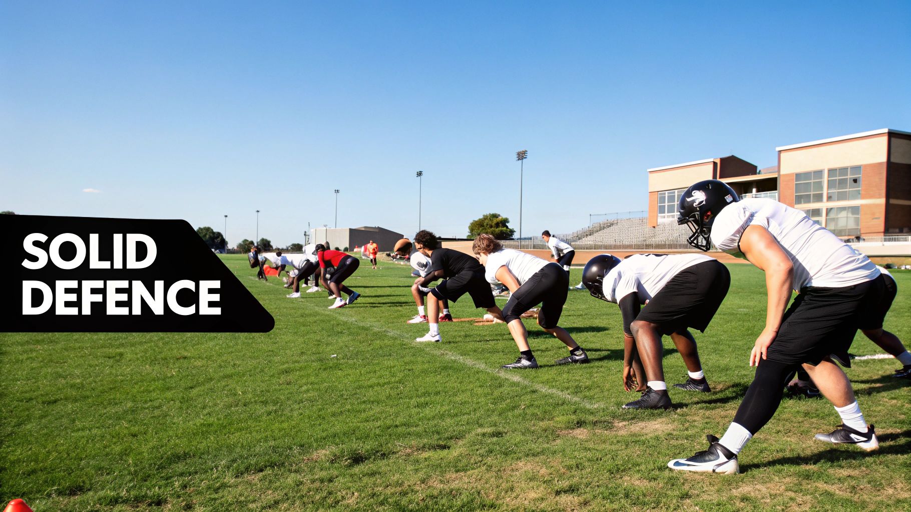 A group of soccer players participating in a defensive drill on a green pitch