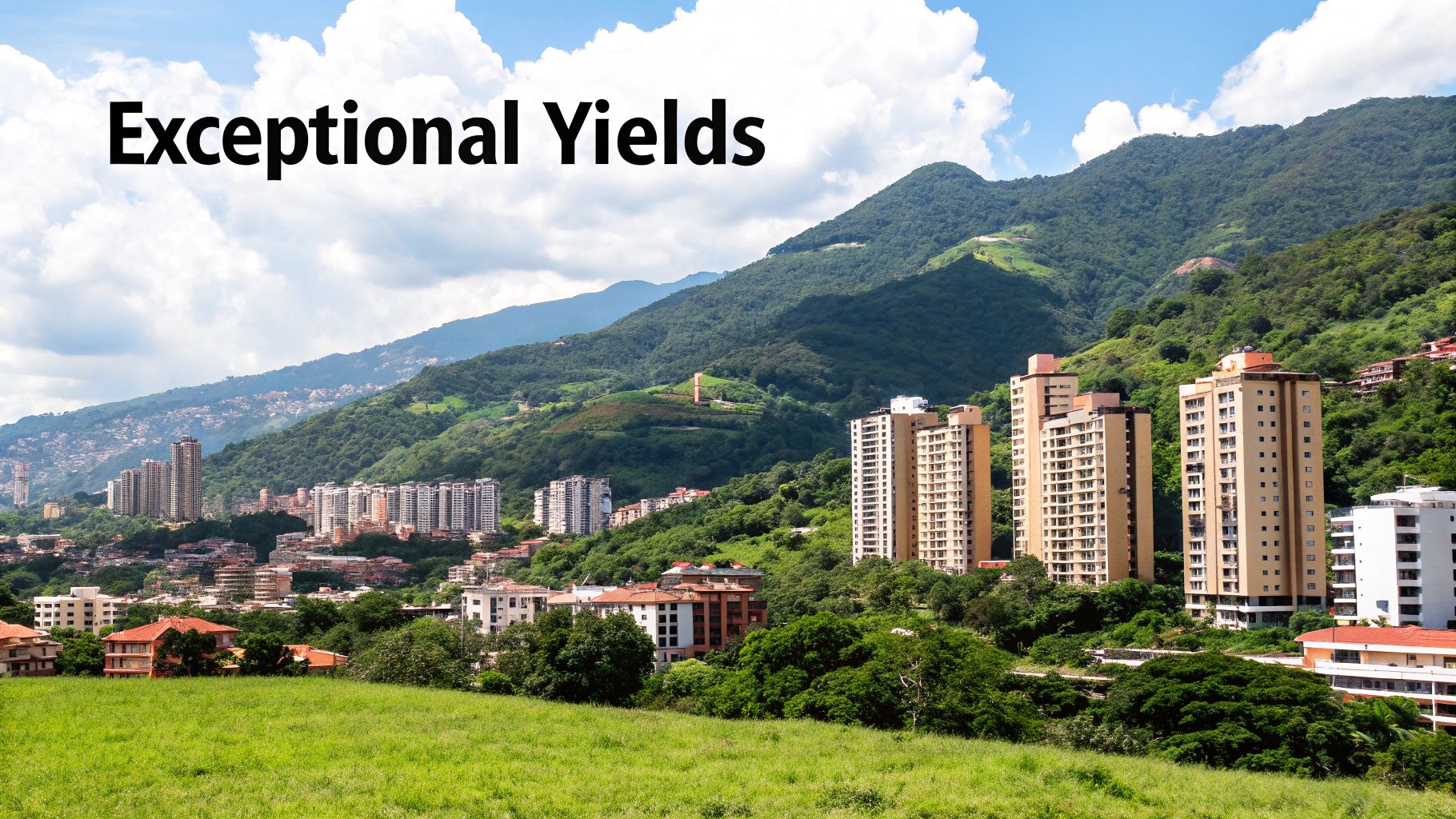 A vibrant city with residential buildings sprawling across lush green mountains under a cloudy blue sky.