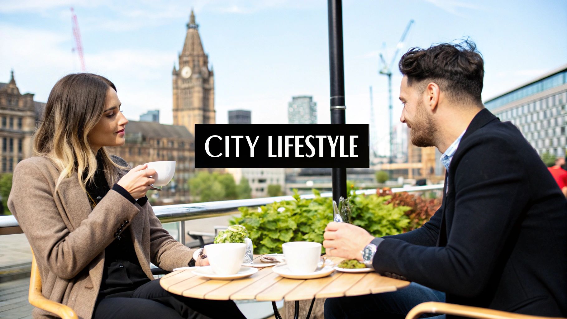 A man and a woman enjoying coffee at an outdoor cafe with a city skyline featuring a clock tower.