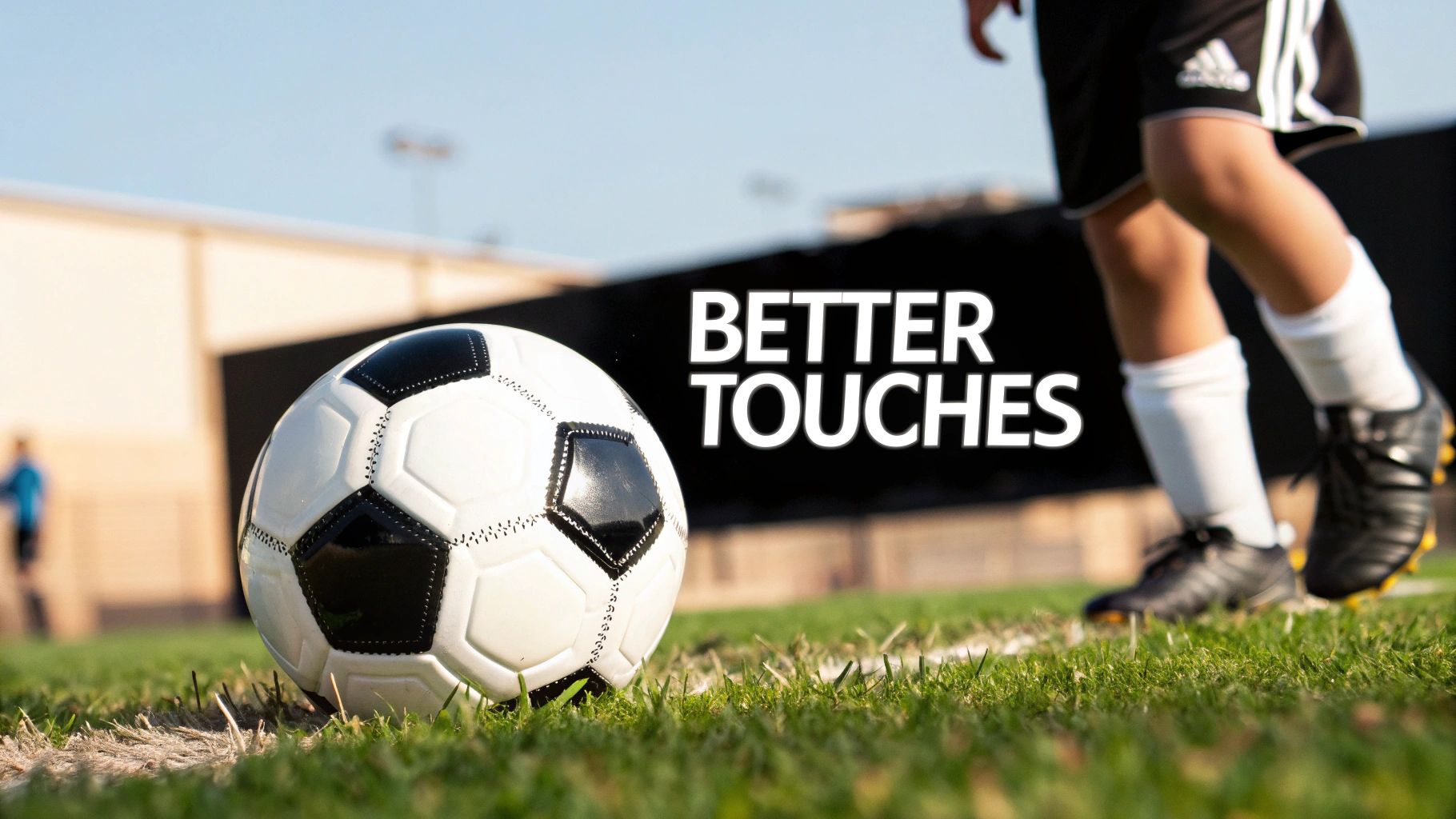 A young soccer player kicking a size 4 ball on a green pitch.