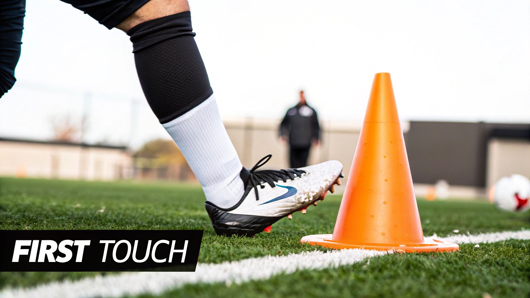 A soccer player controls the ball with a perfect first touch on a green pitch.