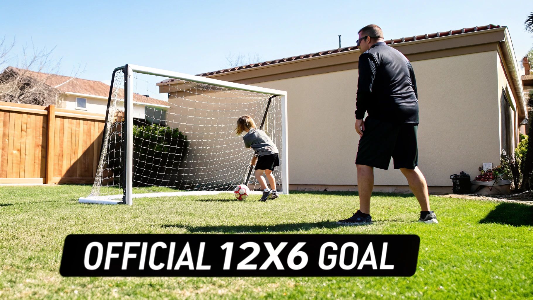 A child and an adult playing soccer in a backyard with an official 12x6 goal.
