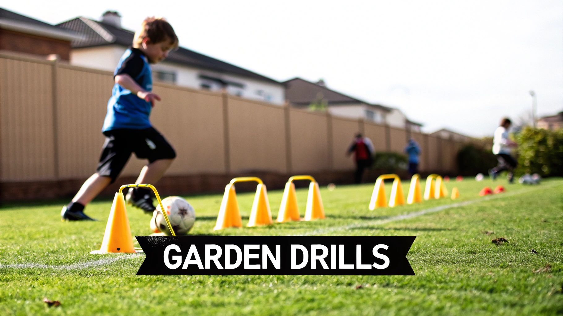 A young boy in a blue shirt dribbles a soccer ball past yellow cones on grass.