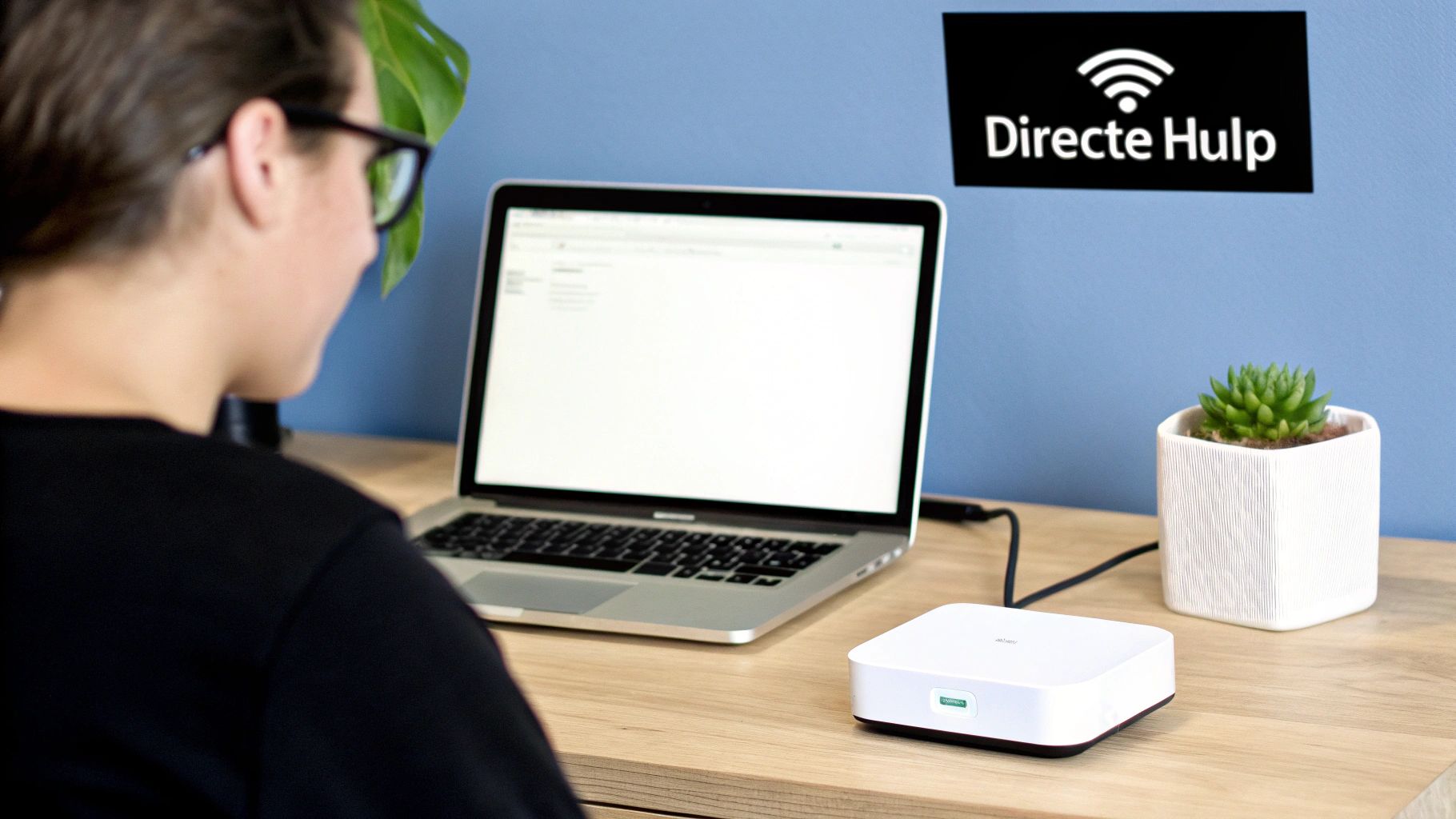 Persoon werkt aan laptop en wit apparaat op een bureau, met 'Directe Hulp' en Wi-Fi logo.