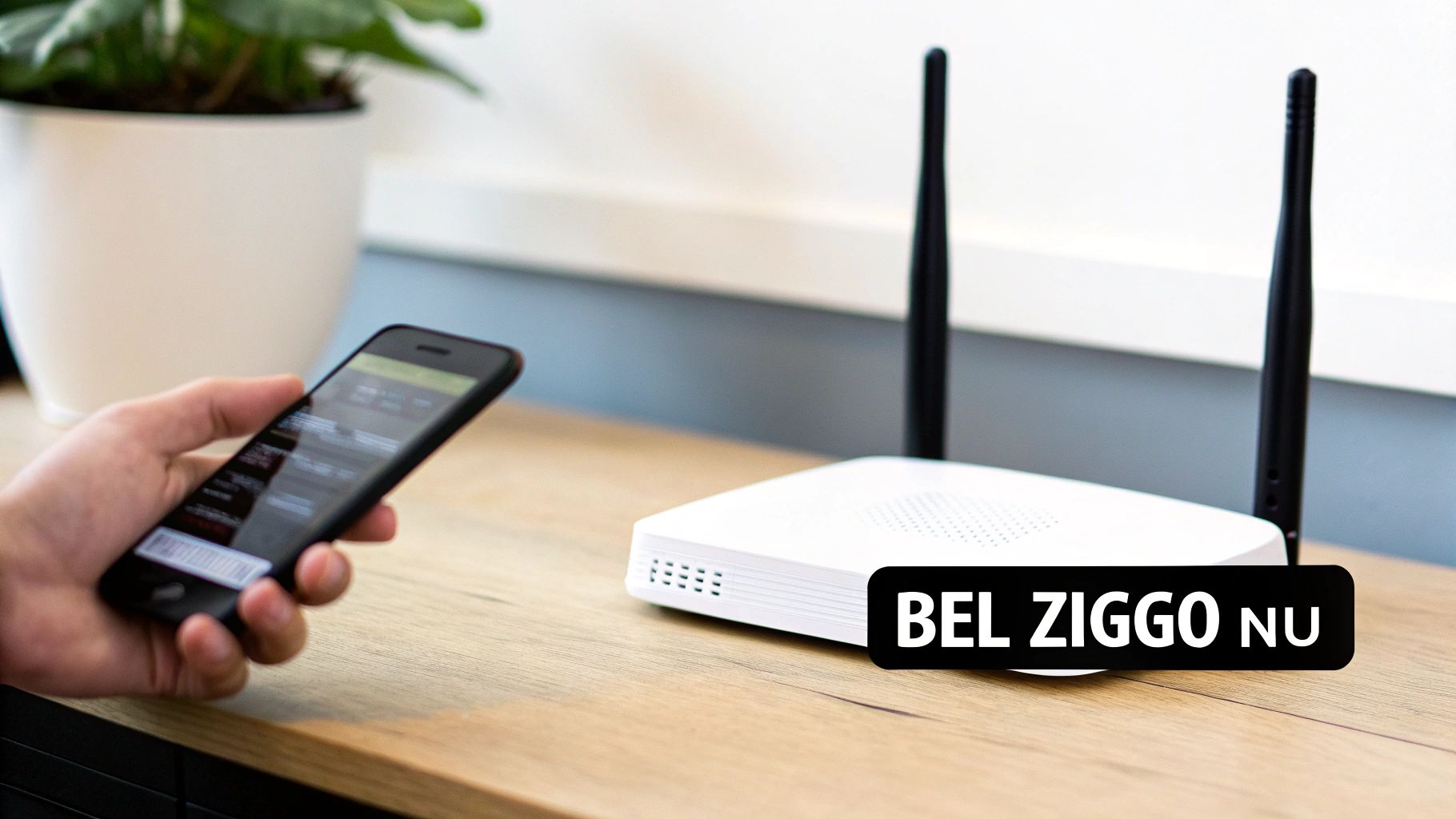 Een hand houdt een smartphone naast een witte wifi-router met twee antennes op een houten bureau, met 'BEL ZIGGO NU' erop.