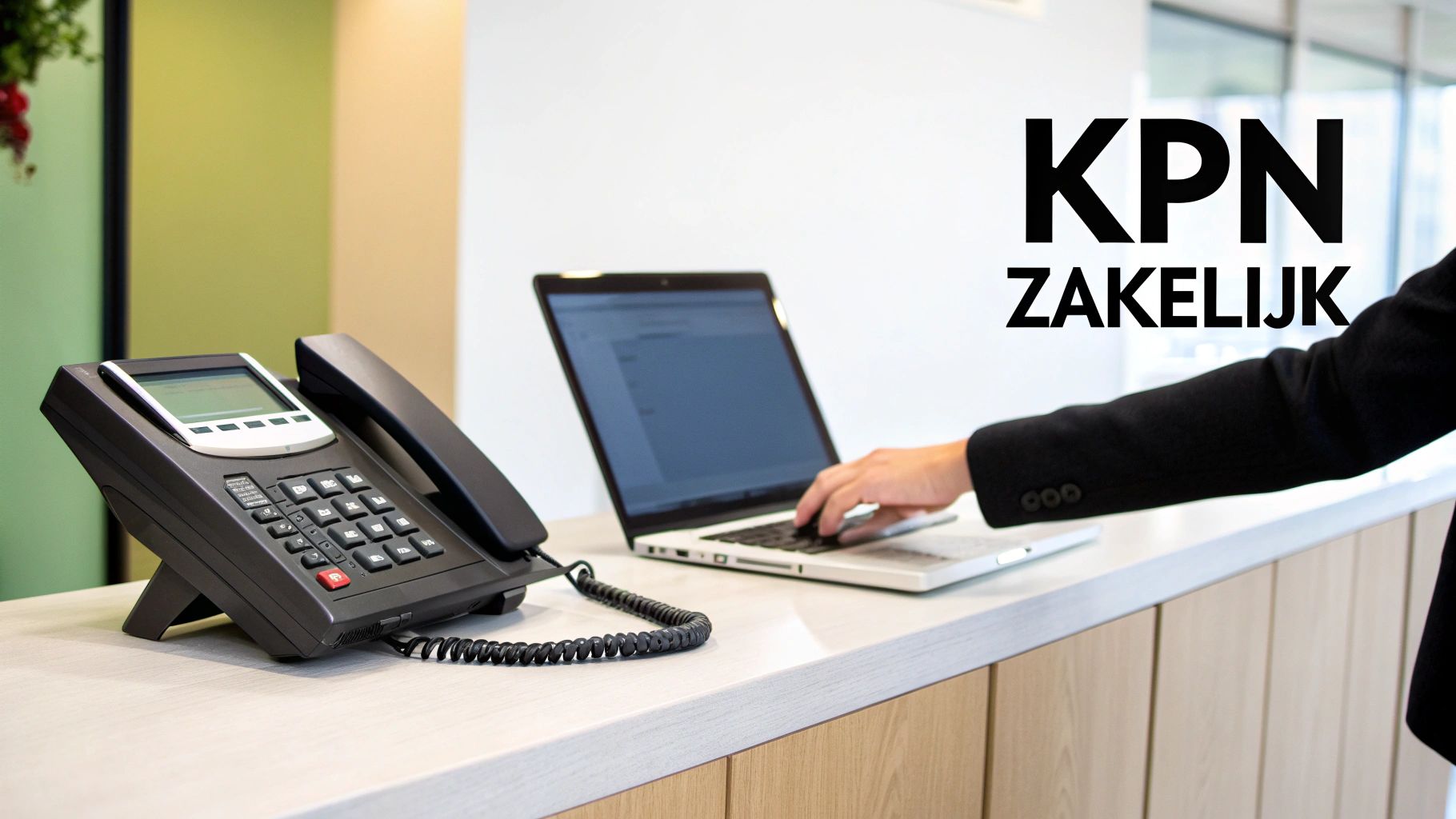 Een zakelijke telefoon en laptop op een bureau, met 'KPN ZAKELIJK' tekst en een persoon die typt.