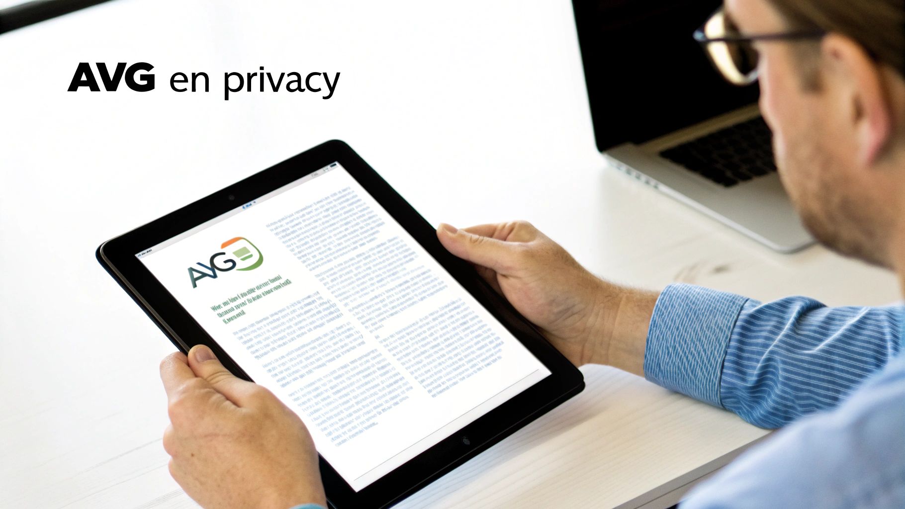 Een man leest content over AVG en privacy op een tablet met een laptop op de achtergrond.