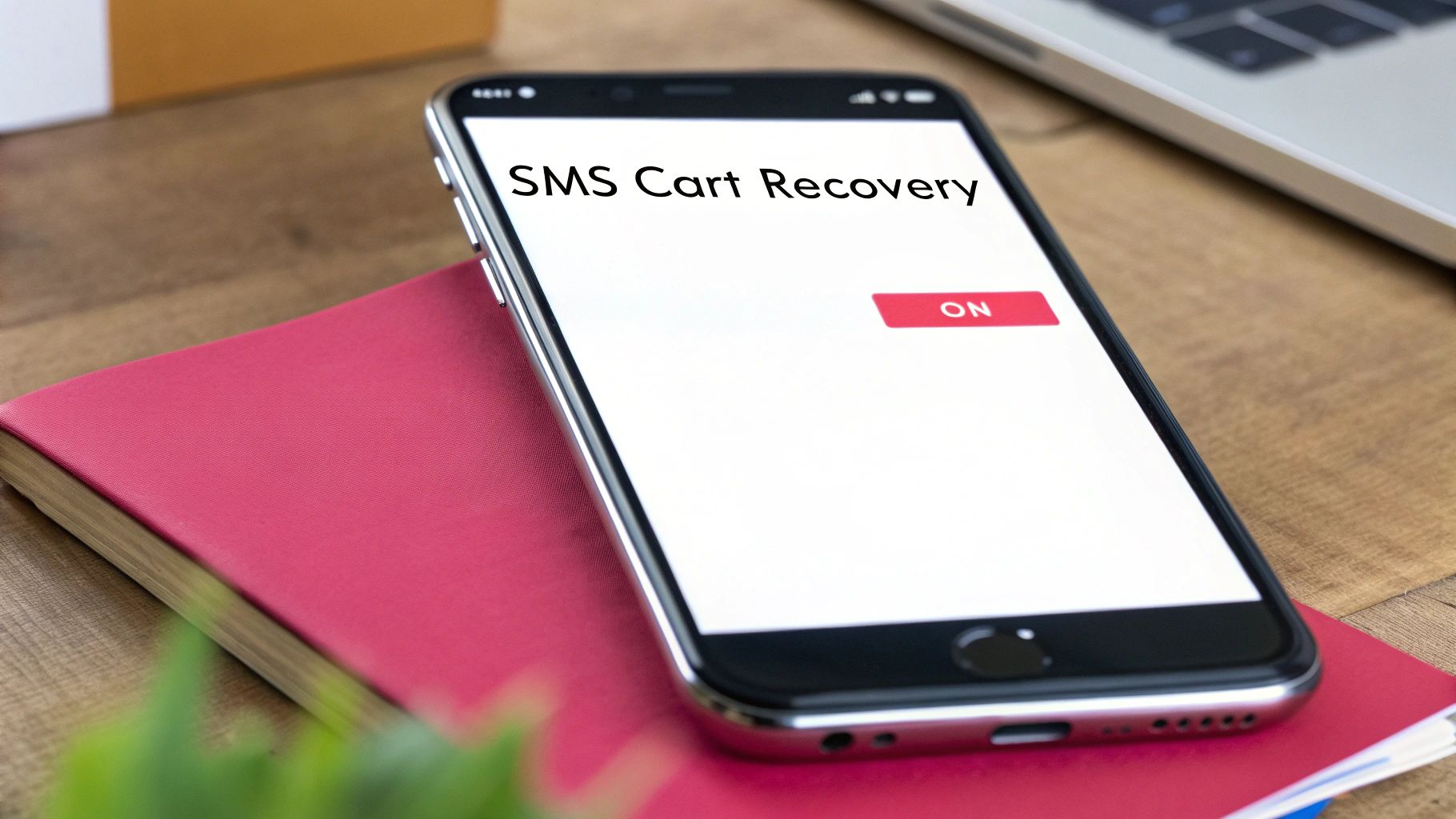 A smartphone screen displays 'SMS Cart Recovery' with an 'ON' button, resting on a red notebook.
