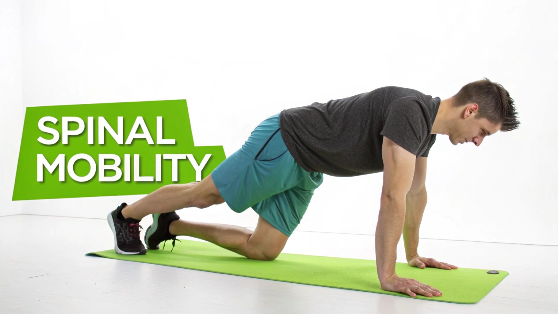 A man on a green mat demonstrating a spinal mobility exercise, positioned on hands and one knee.