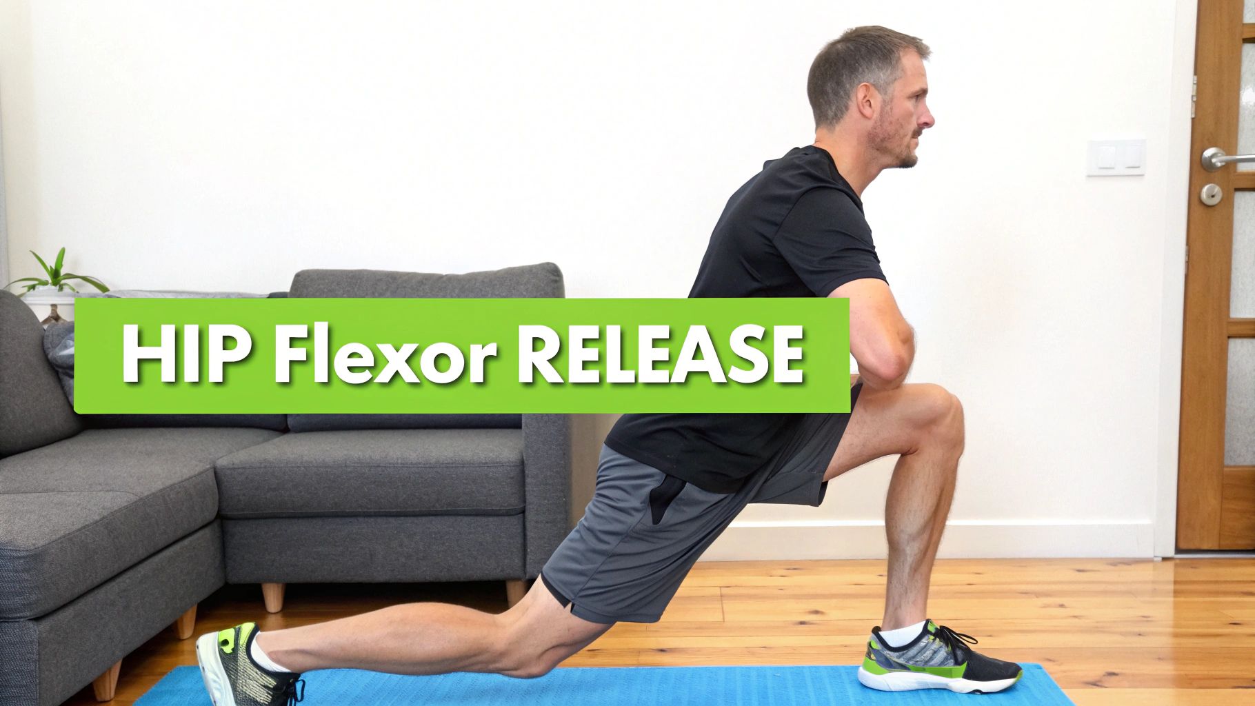A man in activewear performs a hip flexor release lunge stretch on a blue mat indoors.