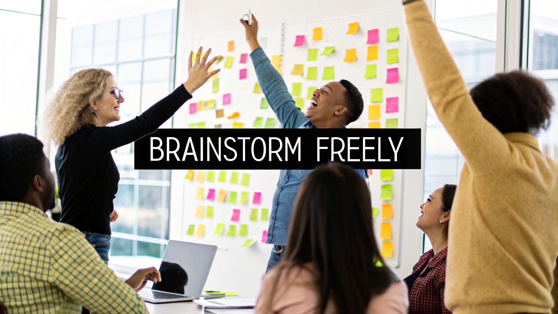 A team collaborating around a whiteboard covered in colorful sticky notes during a brainstorming session.