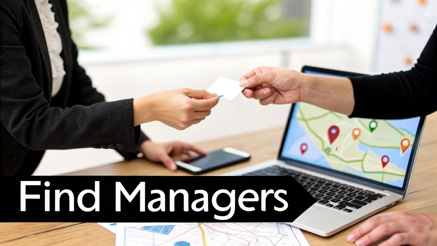 Two business professionals exchanging a business card, with a laptop displaying a location map.